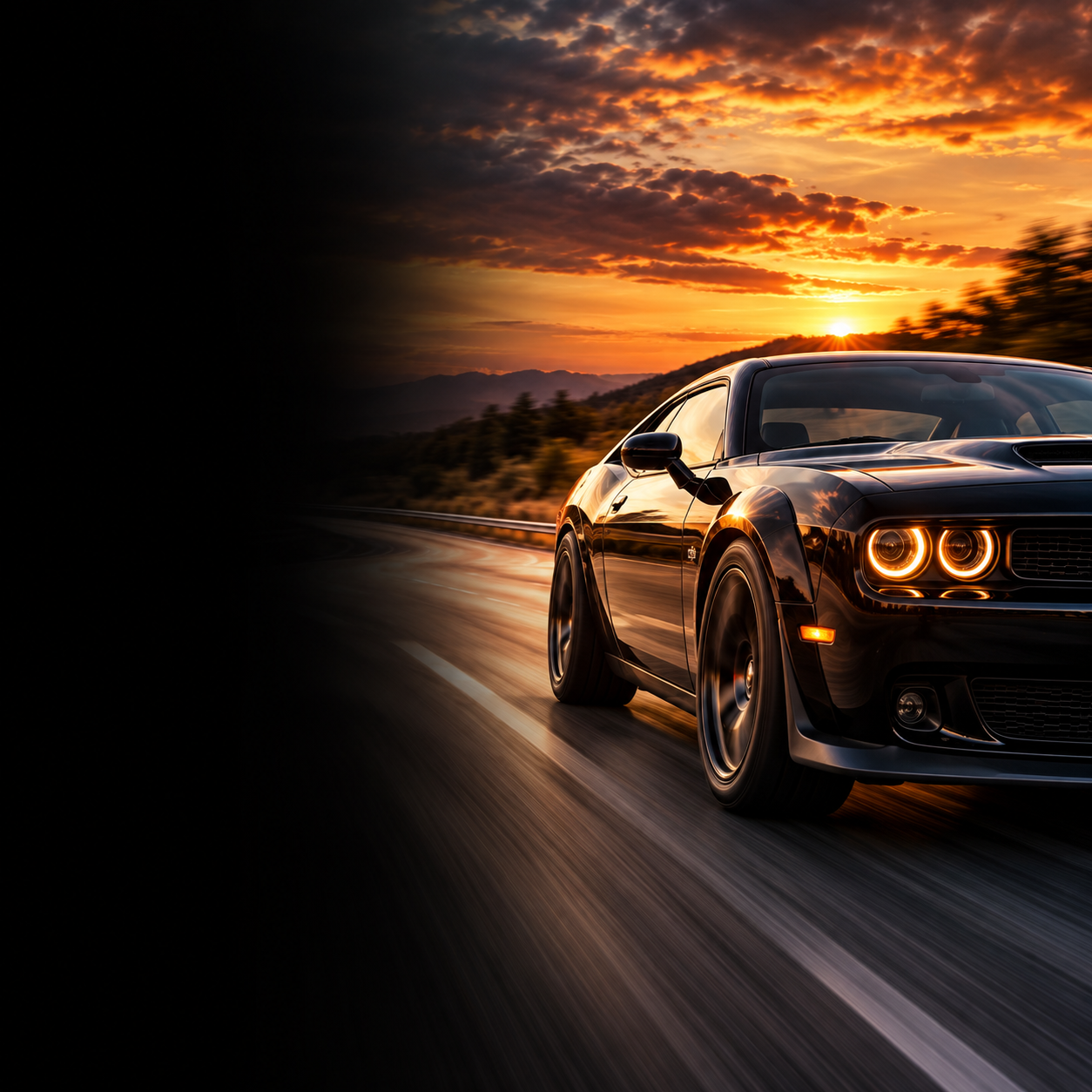 A black sports car driving on a highway at sunset, with a scenic view of mountains and a colorful sky with clouds.
