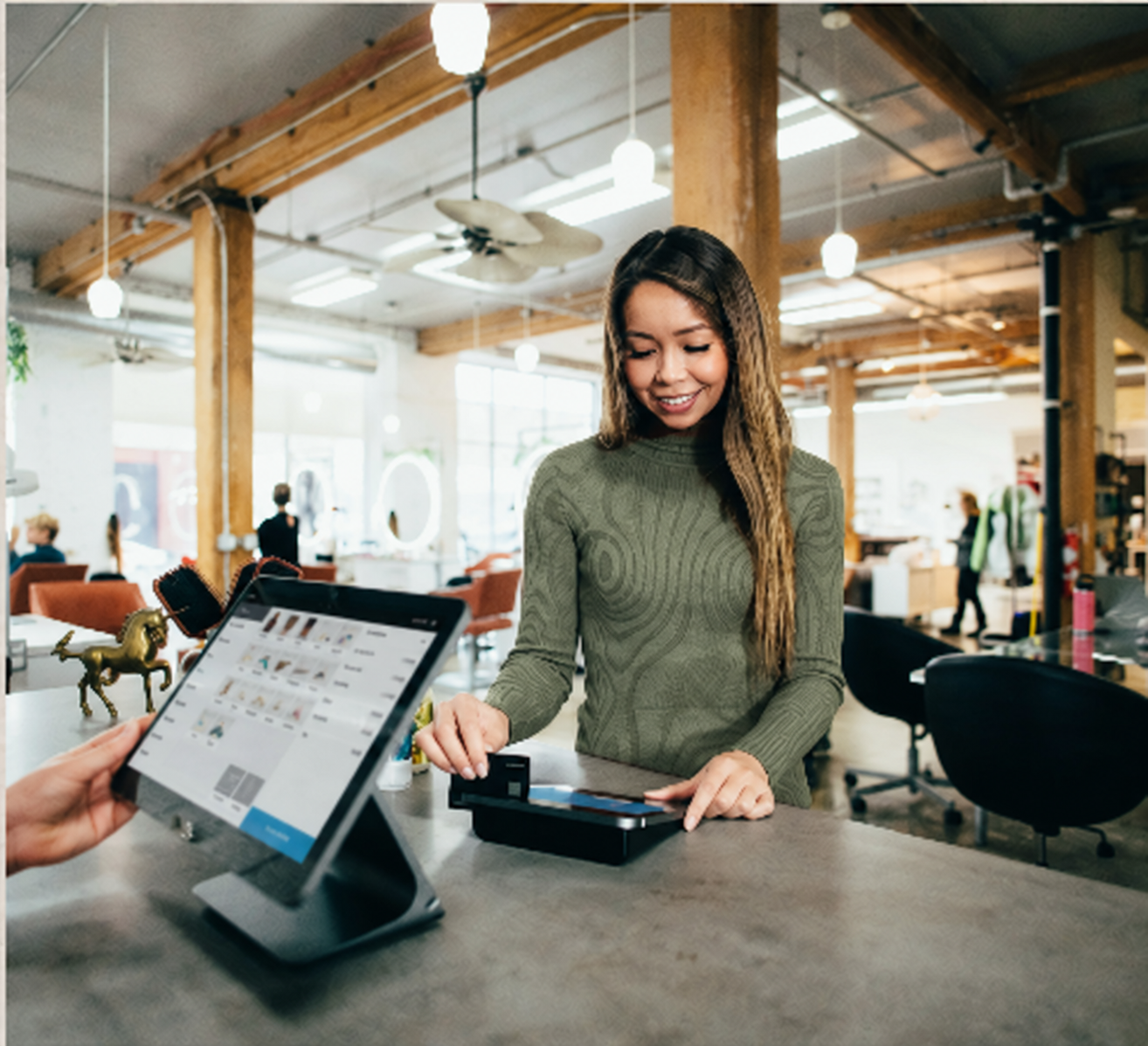 Customer and store clerk completing a payment at a checkout counter.