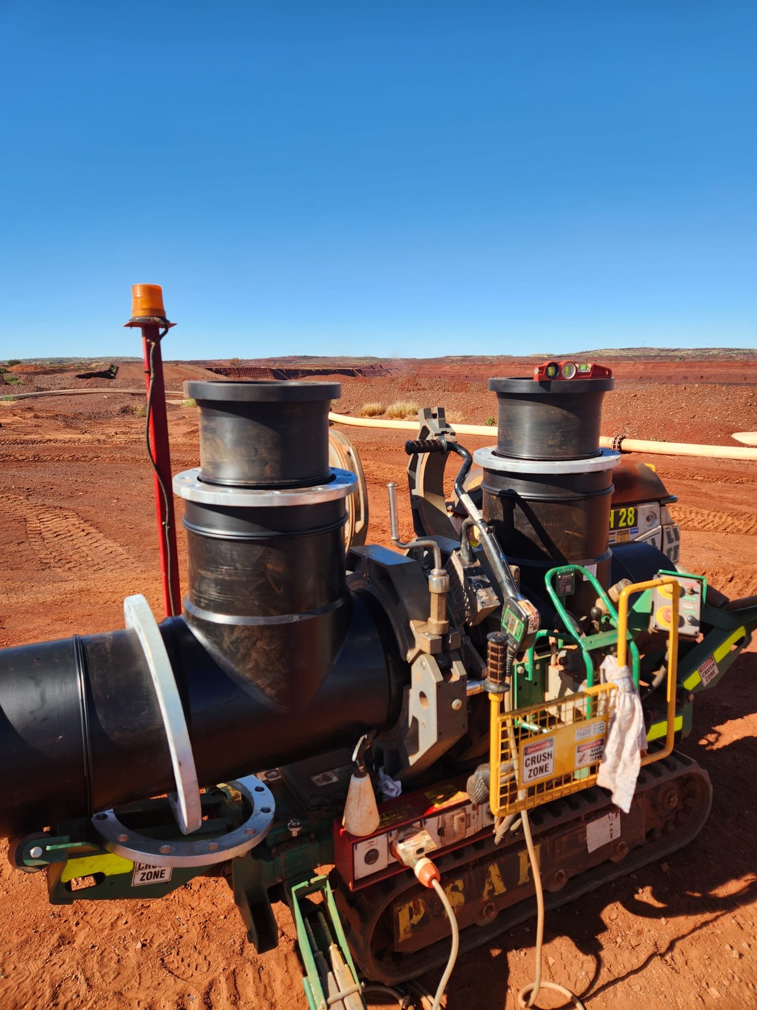 Construction worker's equipment in a desert landscape with a mostly clear blue sky.