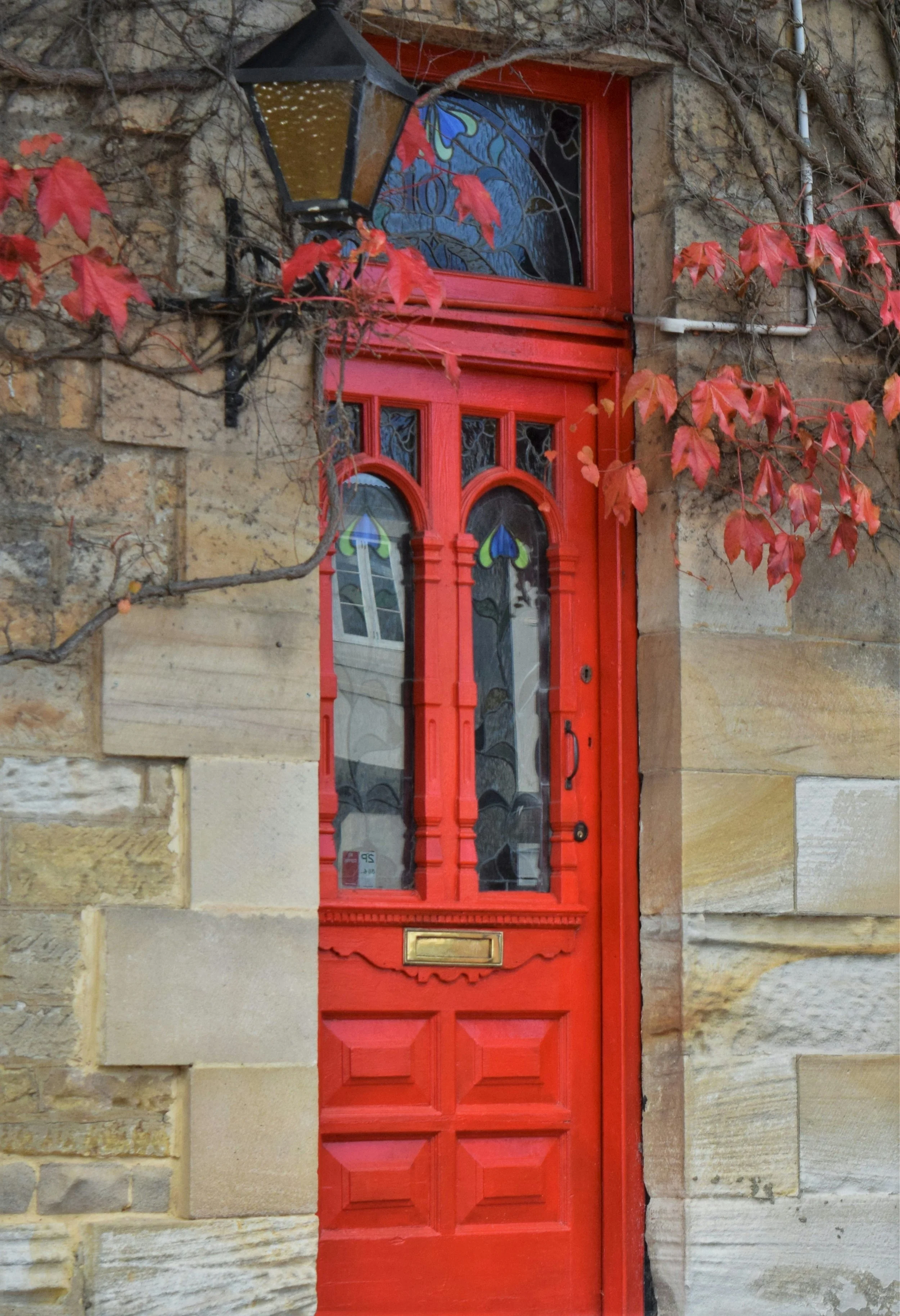 Red front door of a heritage sandstone home