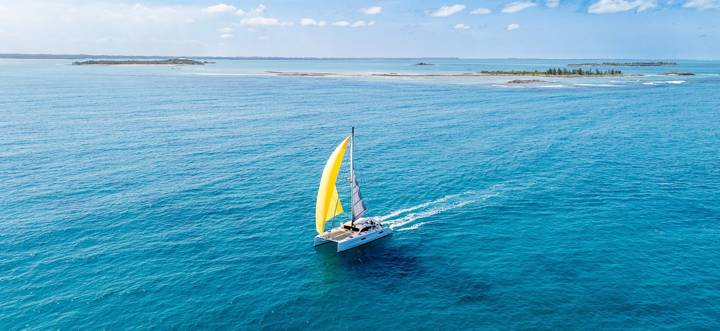 Sailing yacht cruising along a tropical coastline