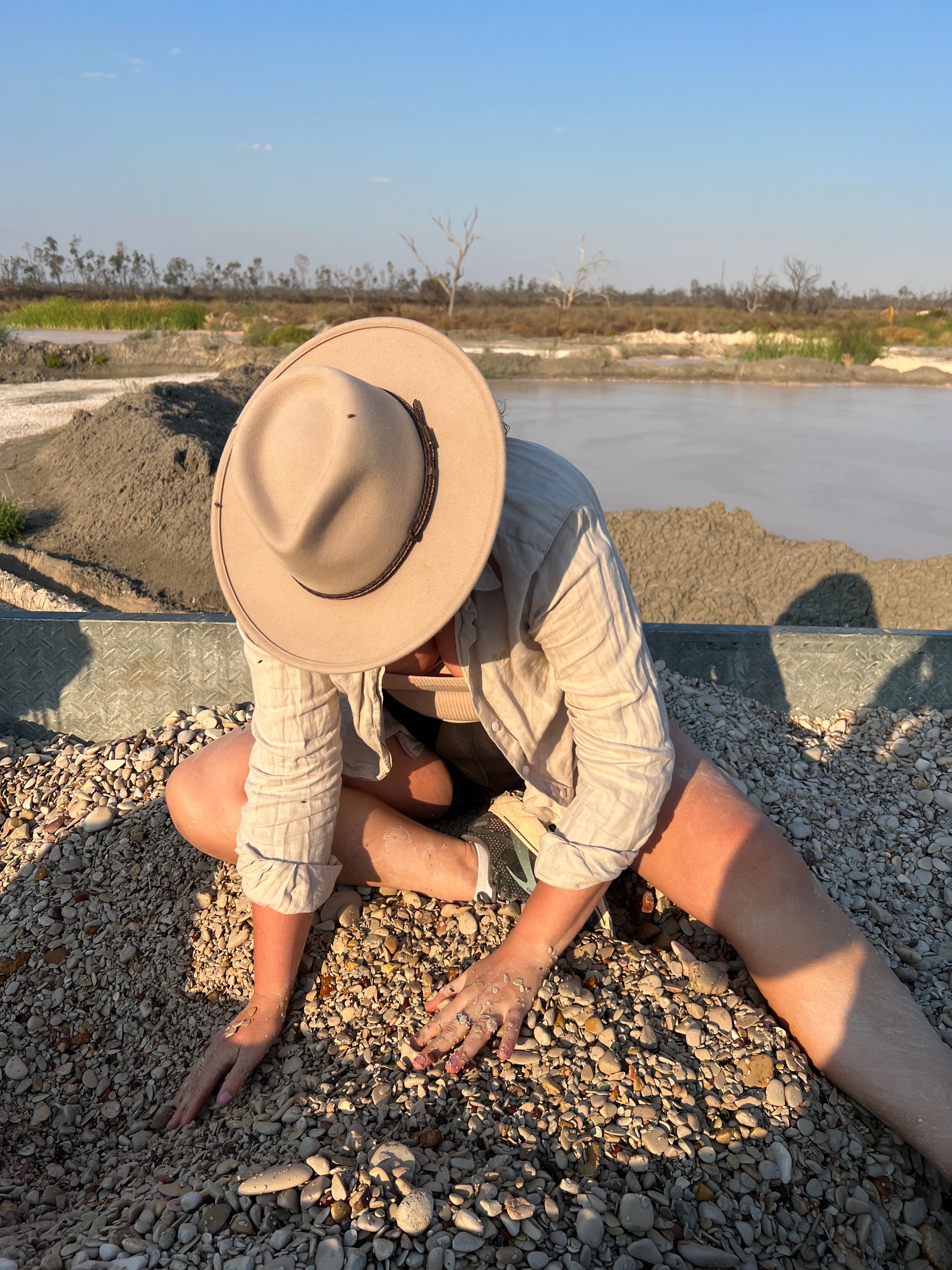Maddy conducting a tail-out sitting on top of a pile of potch and opal.
