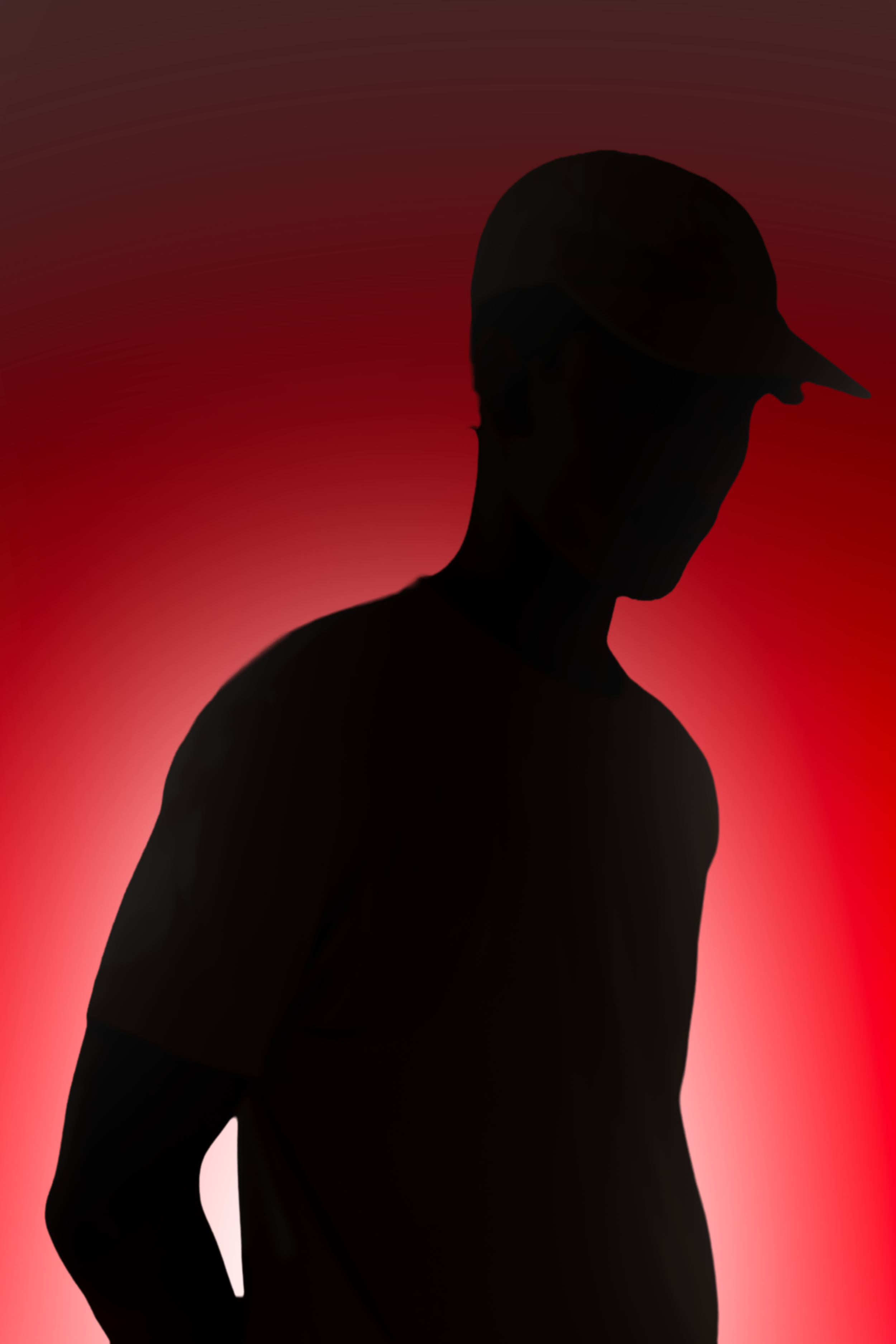 Silhouette of a man wearing a cap against a red gradient background.
