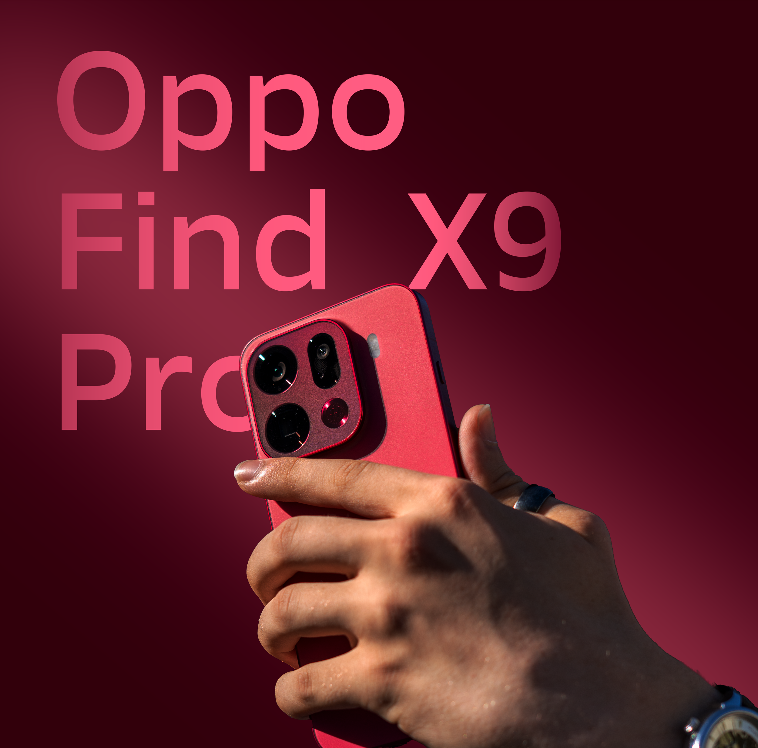 Close-up of a person's hand holding a red Oppo Find X9 smartphone against a dark red background.