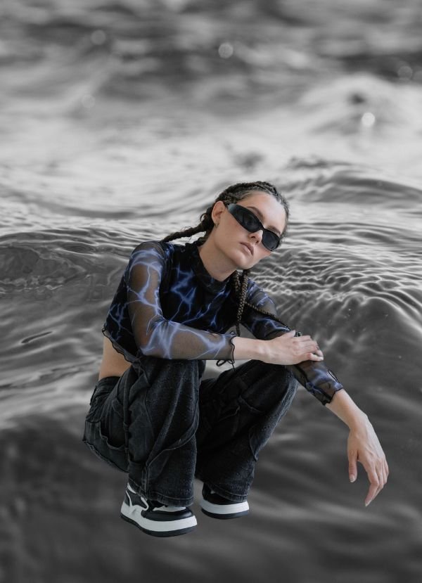 Design model wearing sunglasses with water in the background