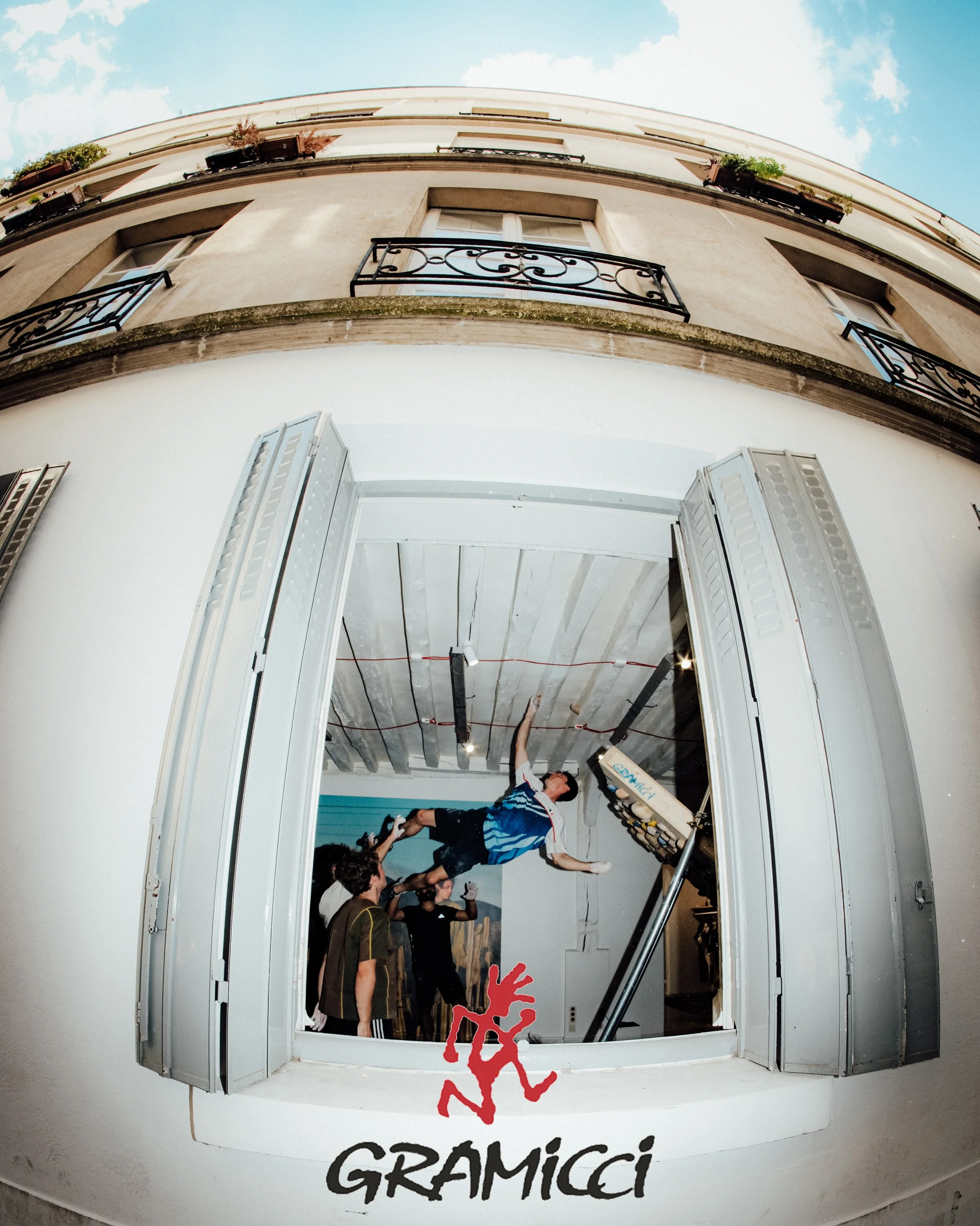 Une photo prise à l'intérieur d'une boutique ou d'un musée, montrant une sculpture ou une statue suspendue au plafond, avec plusieurs personnes en dessous qui semblent faire des activités ou observer. L'image est prise avec un effet de déformation, probablement un objectif fisheye, ce qui donne une perspective incurvée.