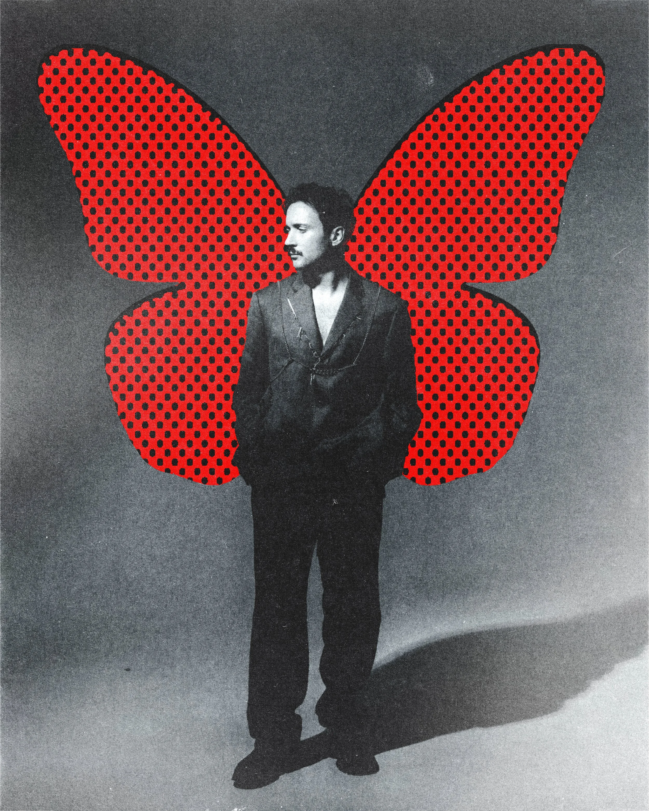 Une silhouette d'homme en costume noir, avec de grandes ailes à pois rouges et noirs derrière lui, sur un fond noir.