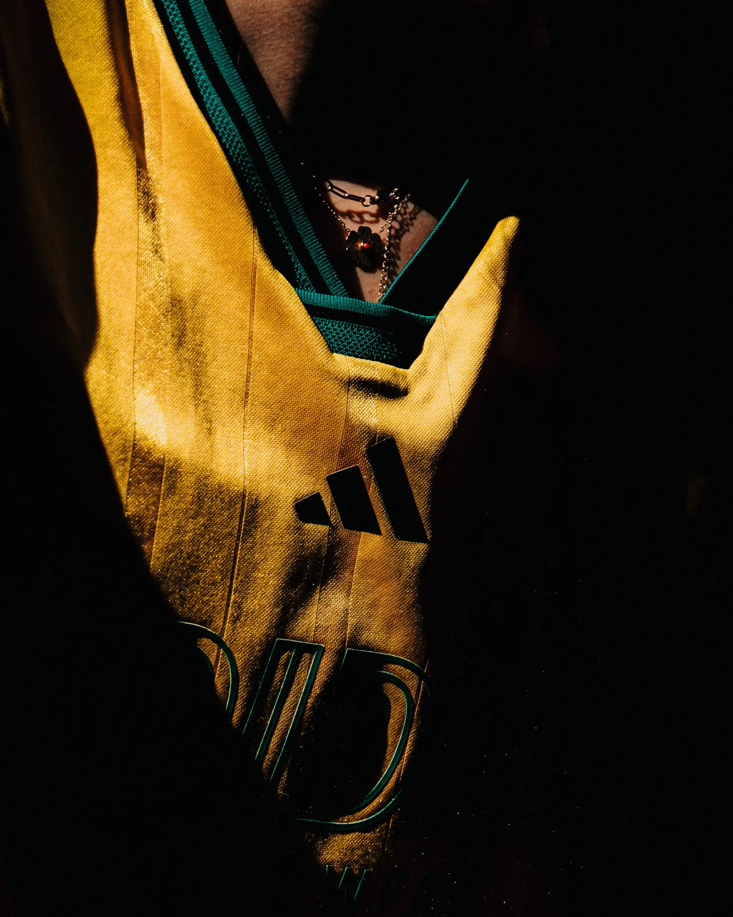 Une chemise ou un maillot en tissu jaune avec un motif noir. La photo est prise dans l'obscurité avec des détails en vert et en noir.