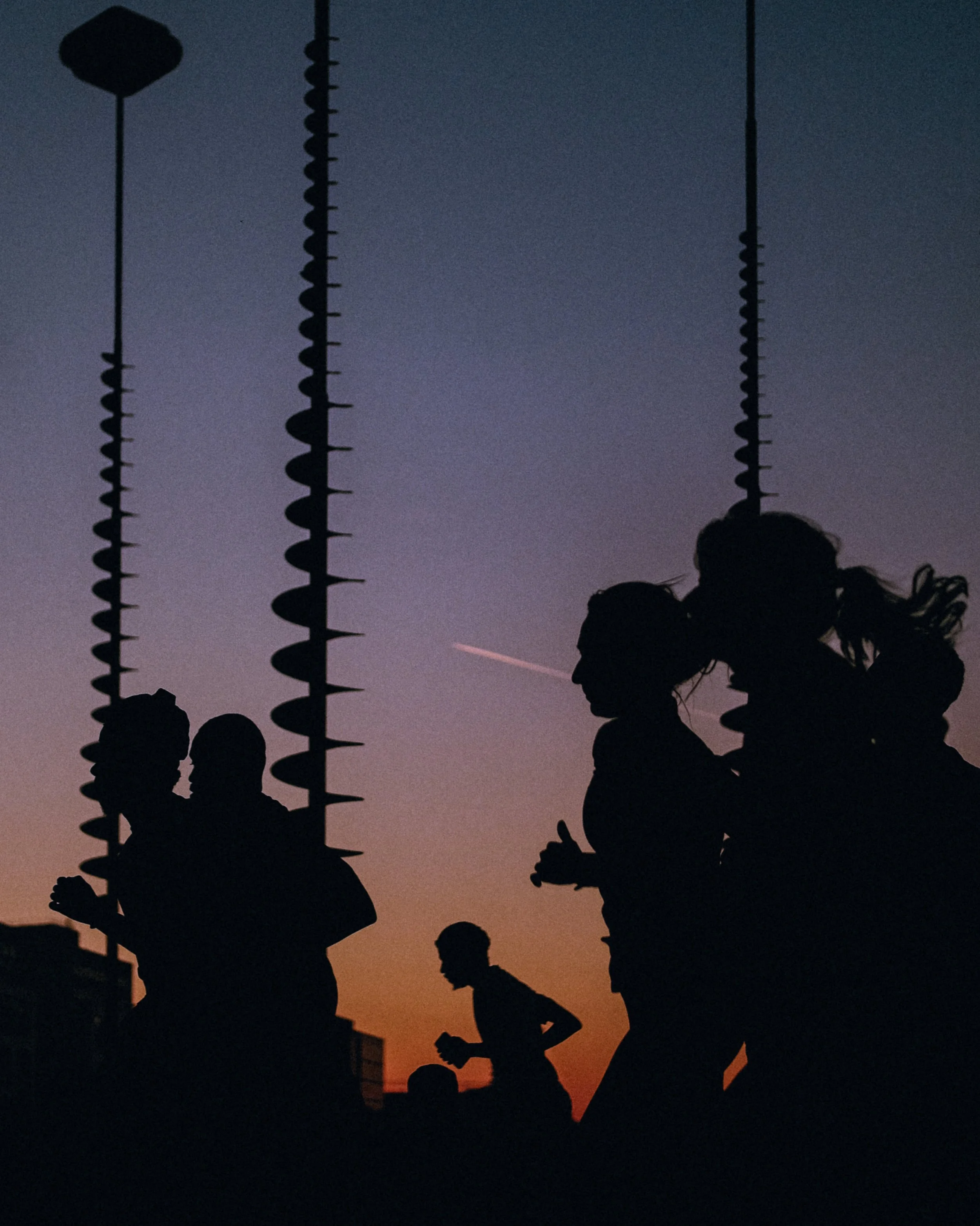 Silhouettes de personnes et de cactus contre un ciel au coucher du soleil.