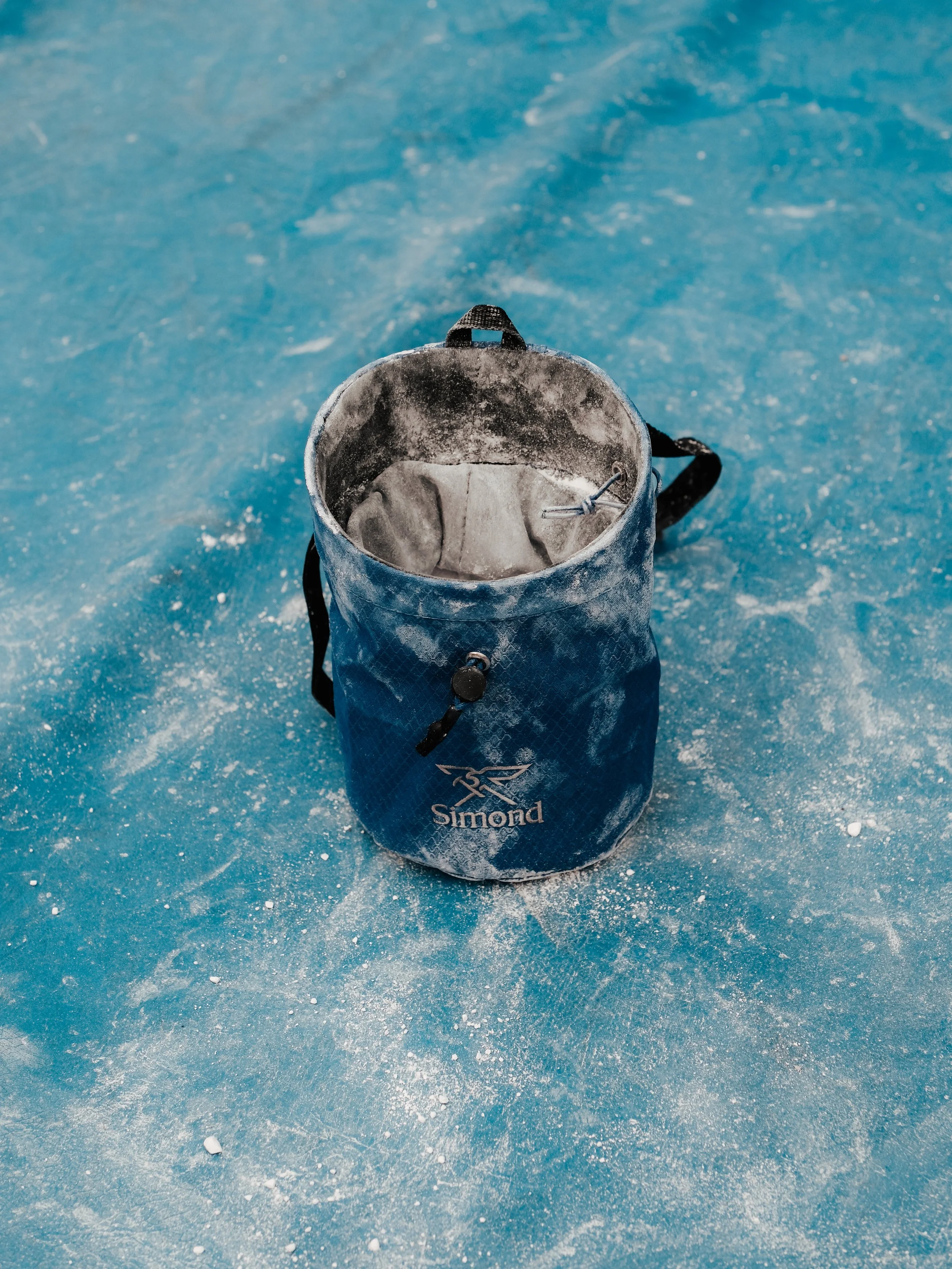 Chaussure d'escalade bleue sur surface glacée, logo 'Simond' visible.