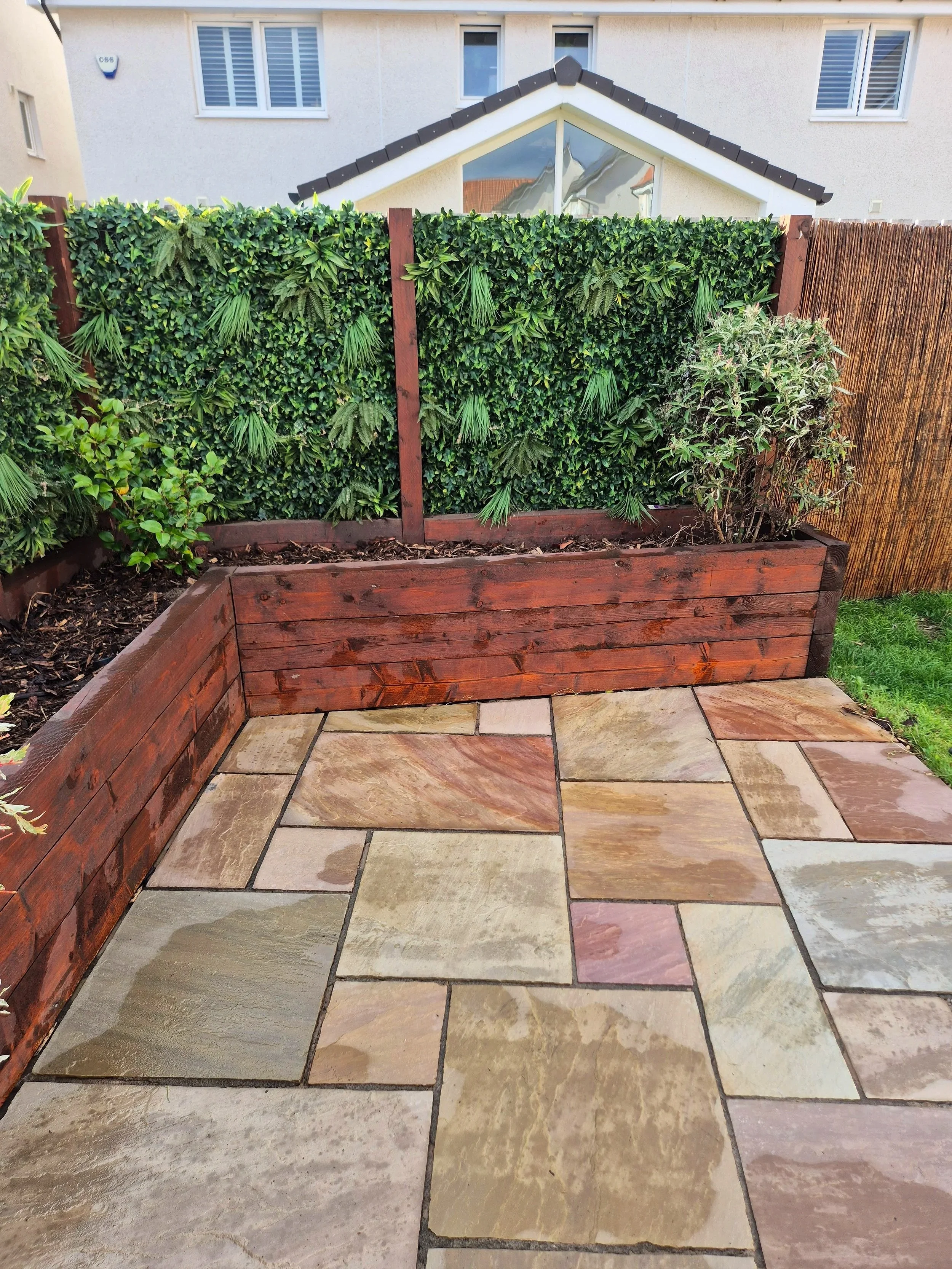 Pressure-washed patio and tidied raised garden bed.