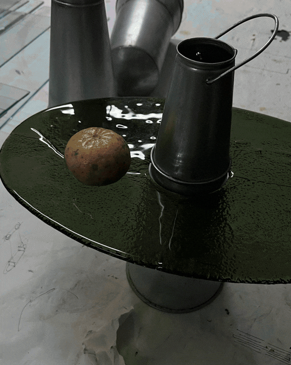 Una mela e un contenitore di metallo su un tavolo nero lucido, con attrezzi metallici sullo sfondo.
