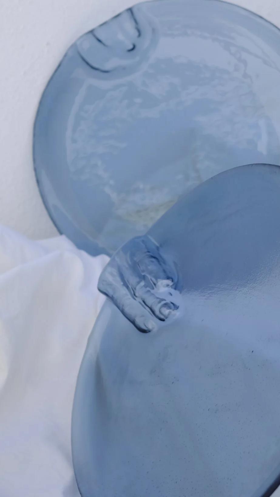 Due piatti di ceramica blu, uno sopra l'altro, su uno sfondo bianco.