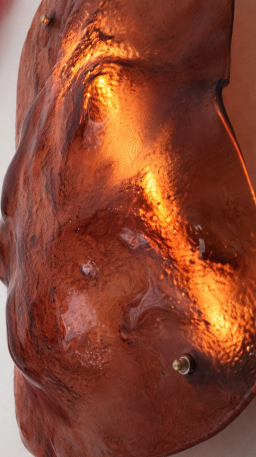 Scultura moderna di una forma umana femminile in materiale metallico con finitura ruggine e luci integrate.