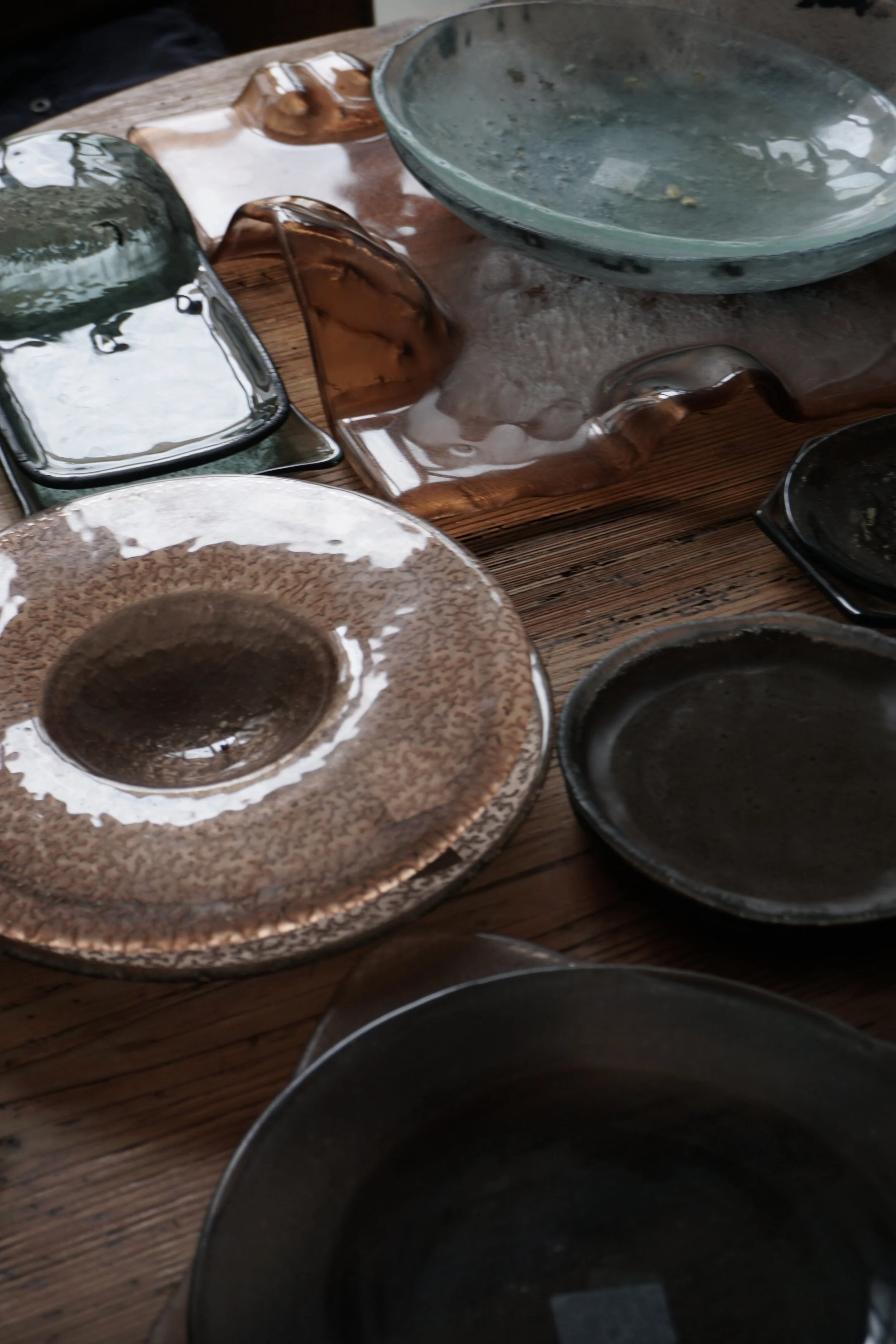 Piatti di ceramica vuoti e alcuni resti di cibo su un tavolo di legno rustico.