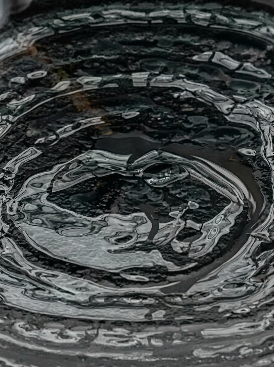 Goccia d'acqua che cade creando cerchi concentrici sulla superficie