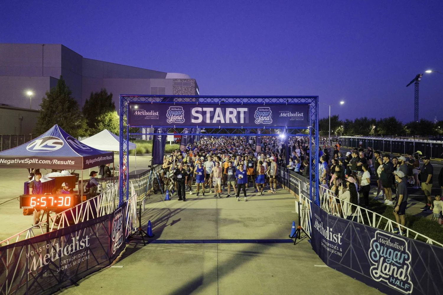 Half Marathon runners lined up beneath the Sugar Land starting arch