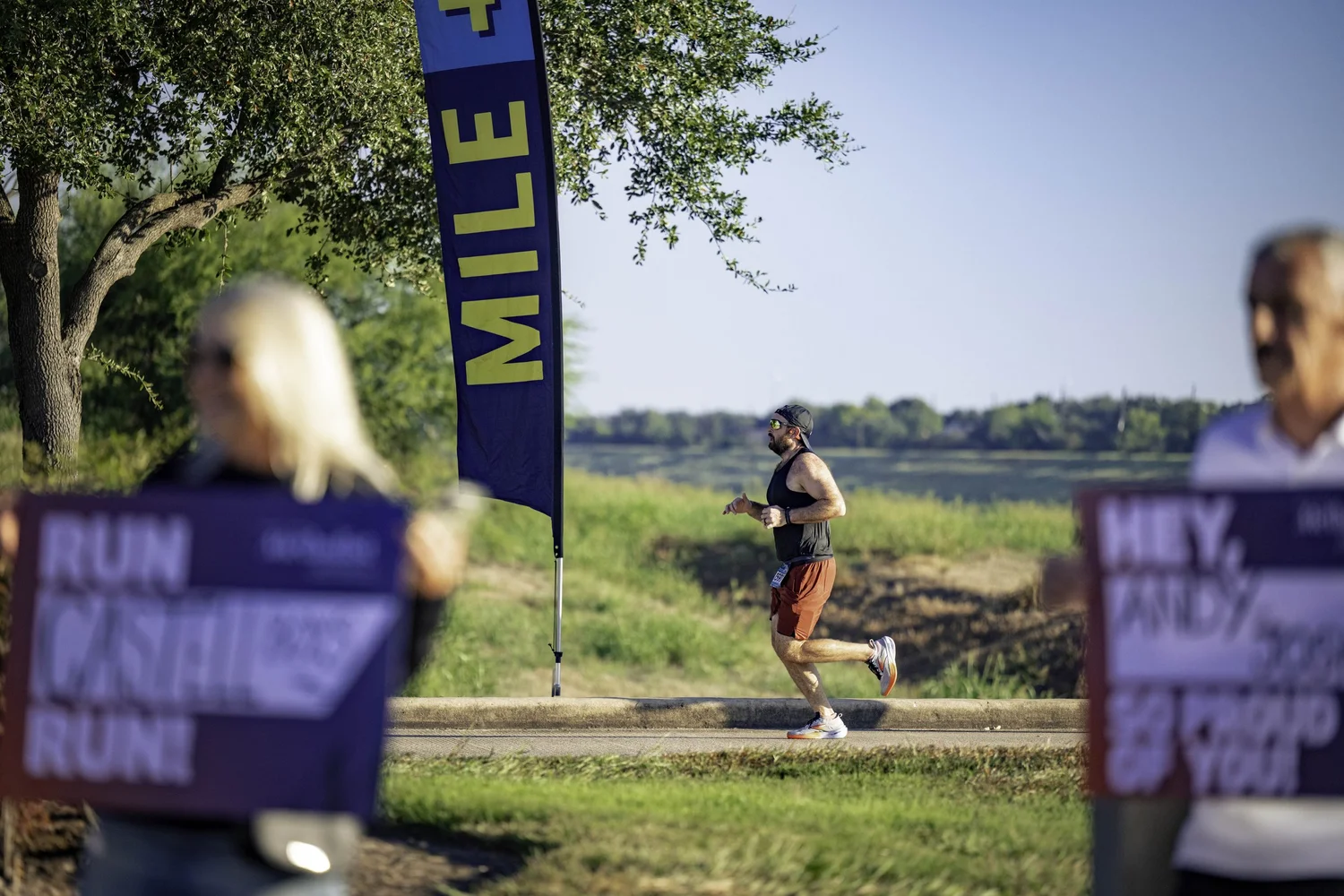 Runner passing a mile marker on the Sugar Land course