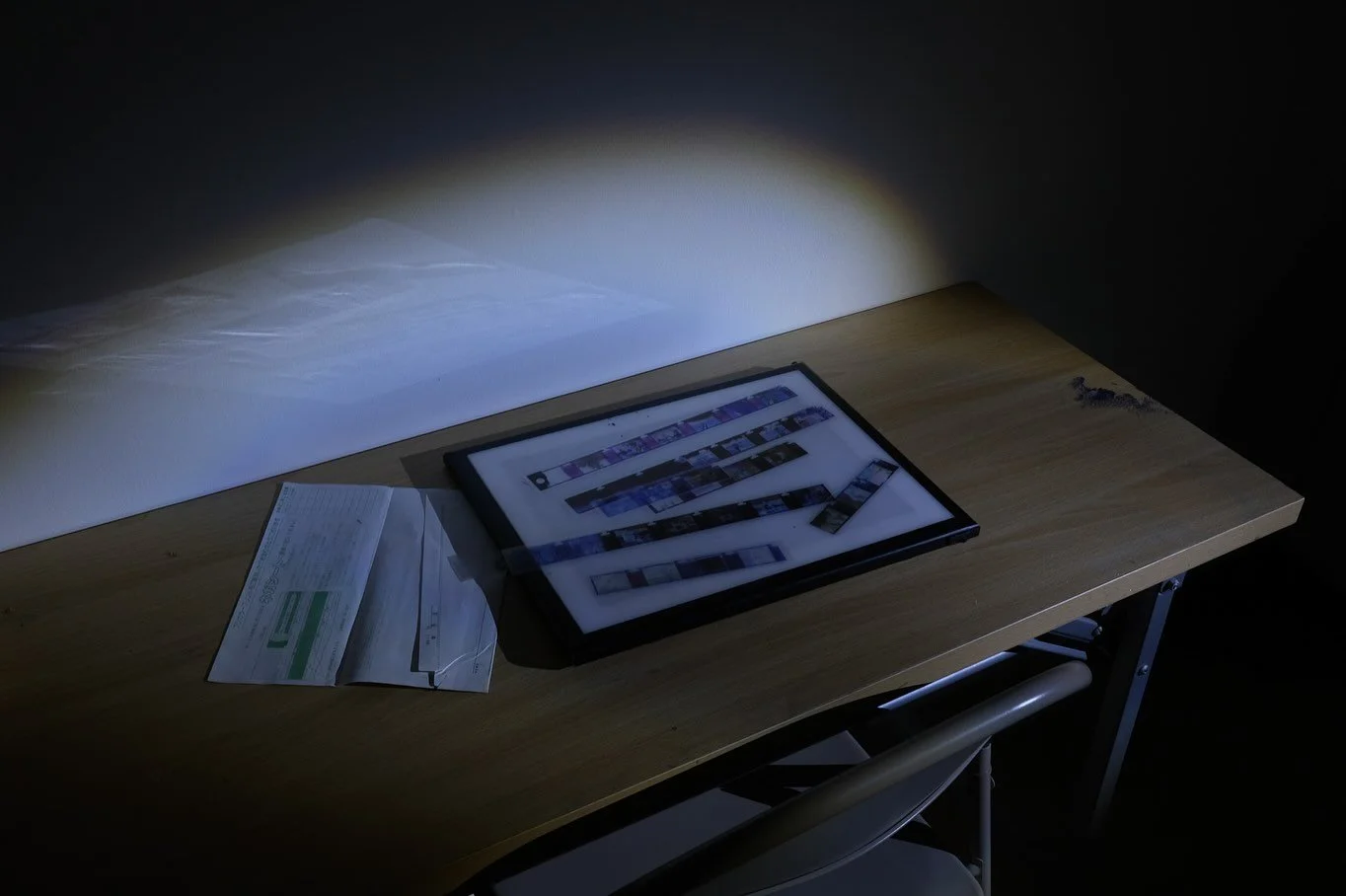 Photographic negatives displayed on a lightbox inside the Ghosts of Tomorrow installation.