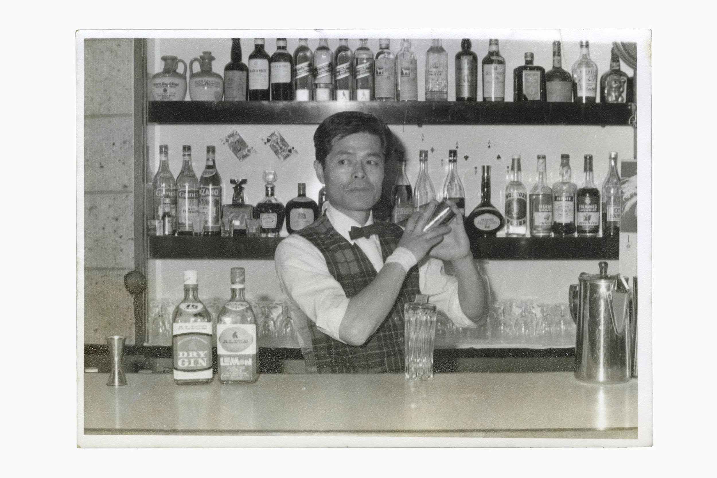 Found black-and-white photograph of a bartender preparing a drink behind a hotel bar in Kinugawa Onsen.