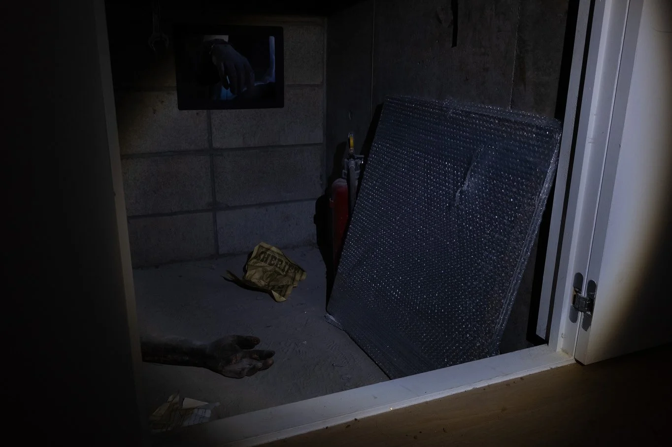 A hand from an animatronic, a flyer from the abandoned Western Village theme park, and a framed photograph of the hand of a similar animatronic, displayed in the *Ghosts of Tomorrow* installation at Gallery ETHER.