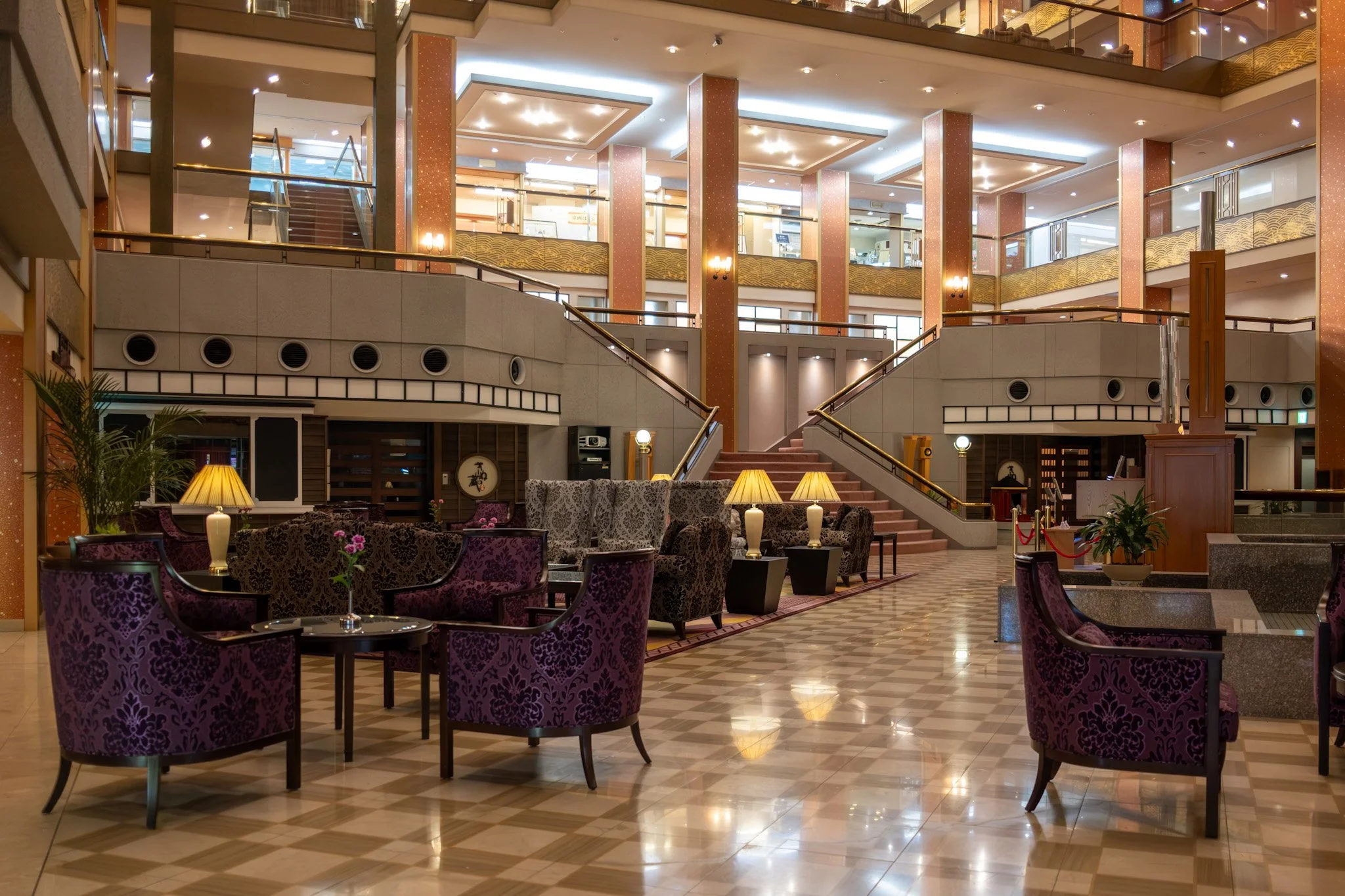 Interior of Asaya Hotel, an operating hotel lobby in Kinugawa Onsen, with seating and a central staircase.