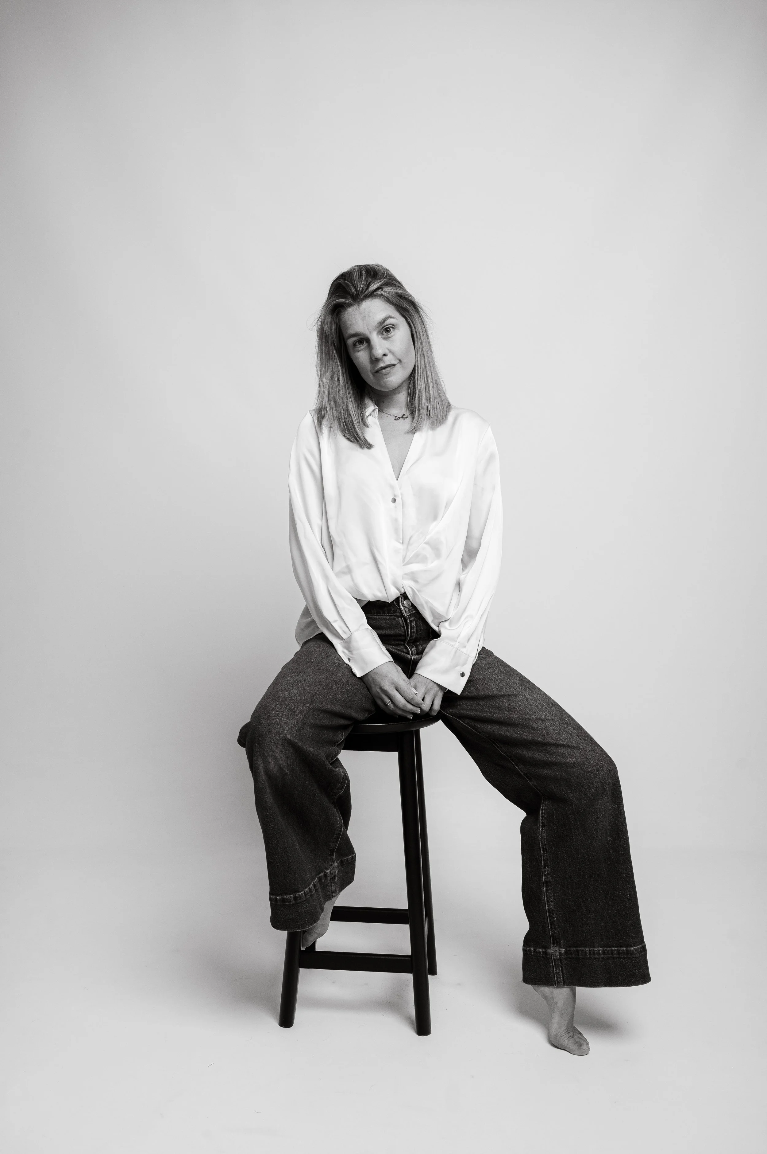Black and white image of celebrity fashion stylist Megan Smales sitting on a chair
