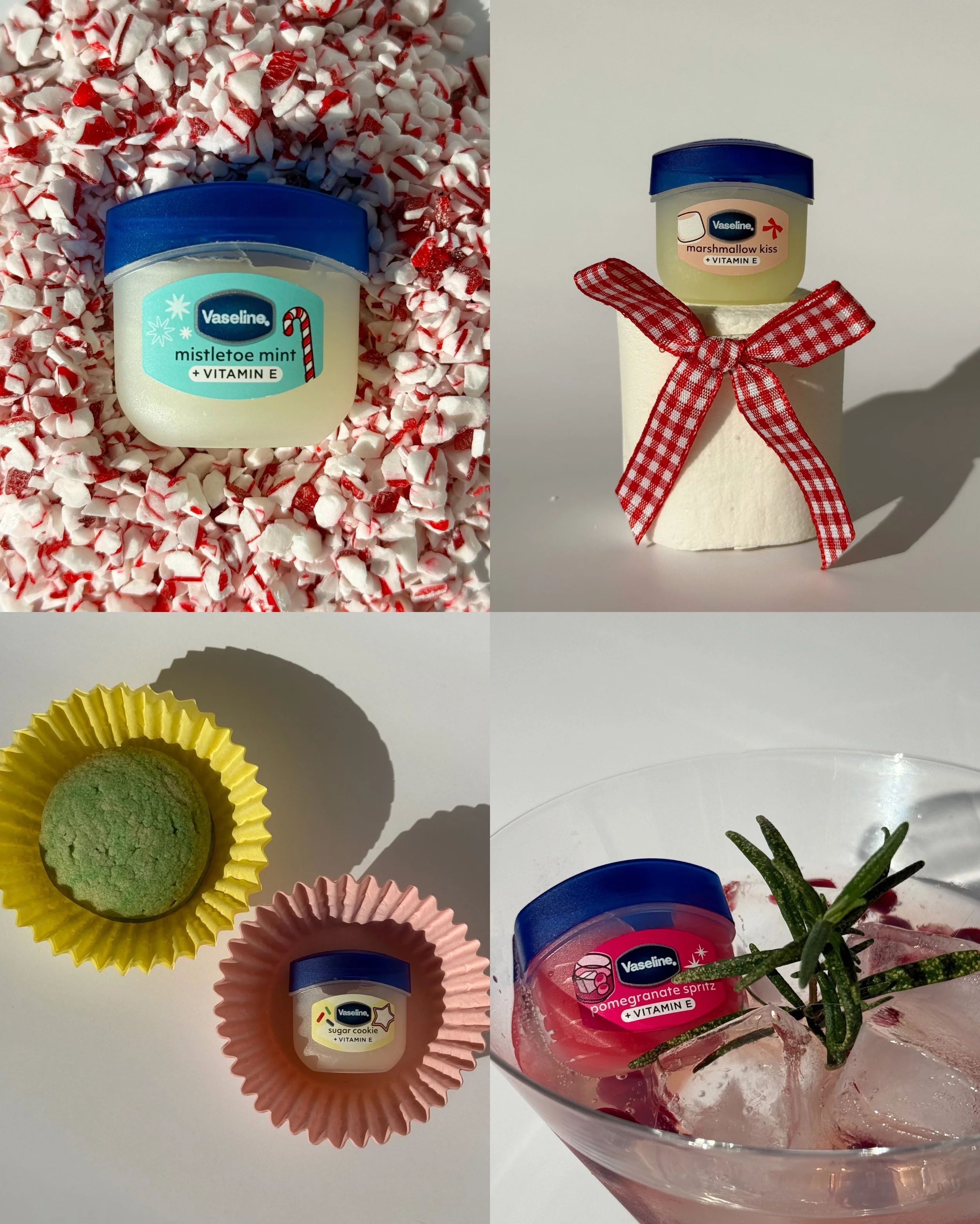 Four jars of Vaseline lip balm with holiday-themed labels, surrounded by colorful cupcake liners, peppermint candies, and fresh rosemary sprigs on a white surface.