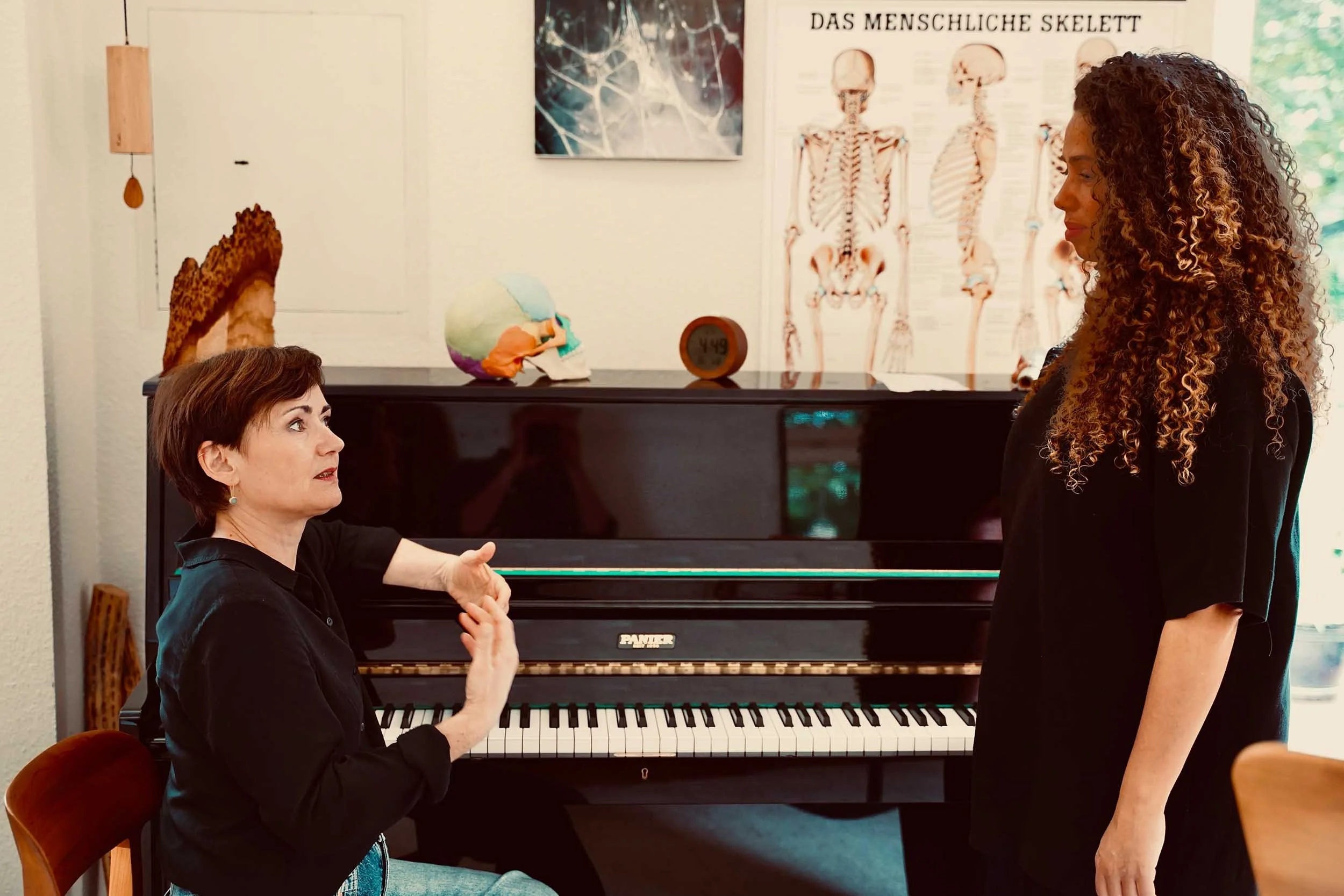 Gesangsstunde am Klavier: Therapeutin arbeitet mit einer Sängerin an der Stimme, Stimmbildung in Köln-Ehrenfeld