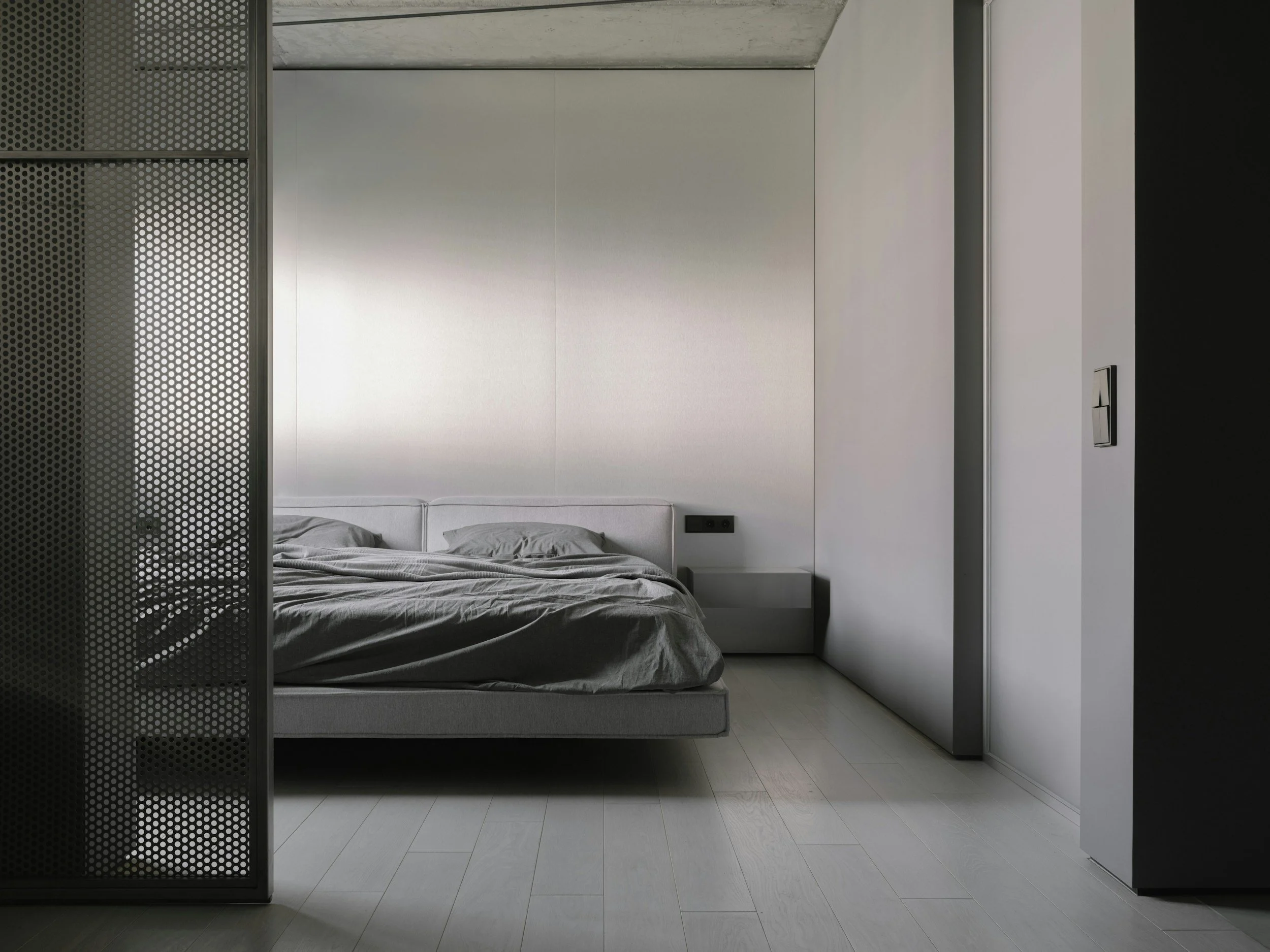 Minimalist bedroom with gray bedding and soft natural light