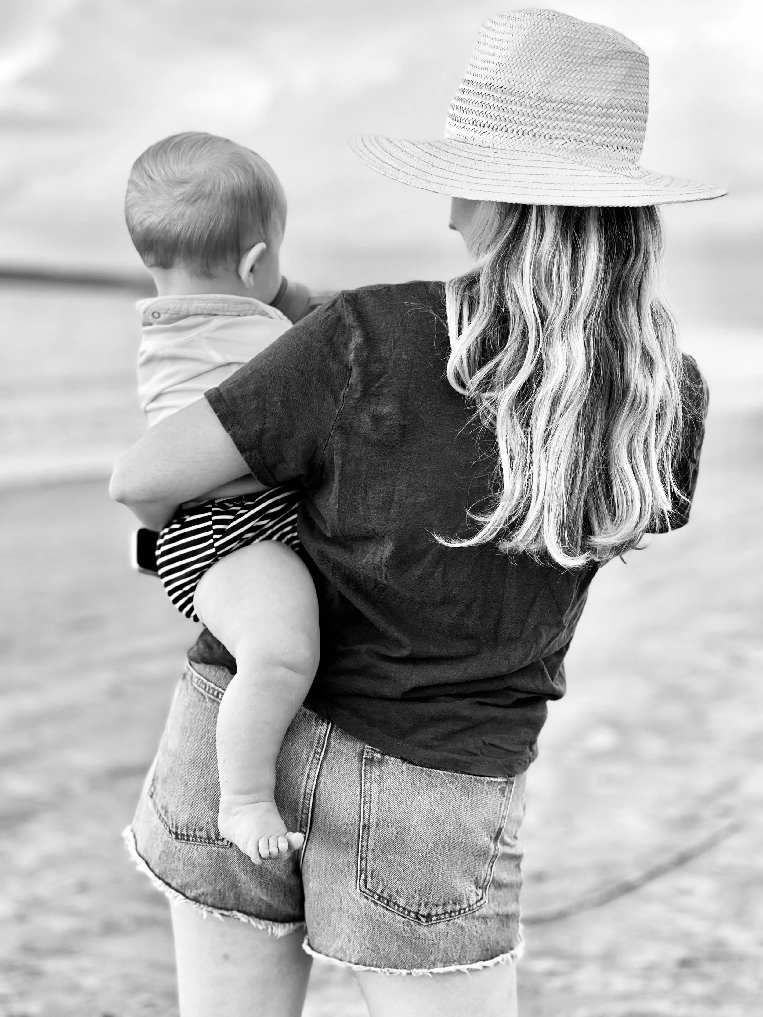 Sarah Penney Reed holding a young child at the beach