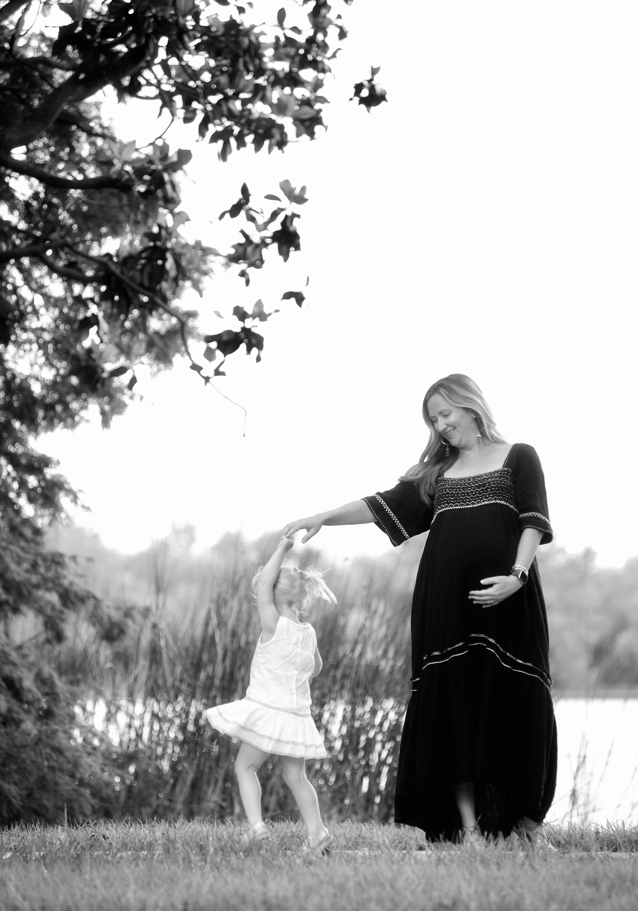 Sarah Penney Reed with a young child outdoors near the water