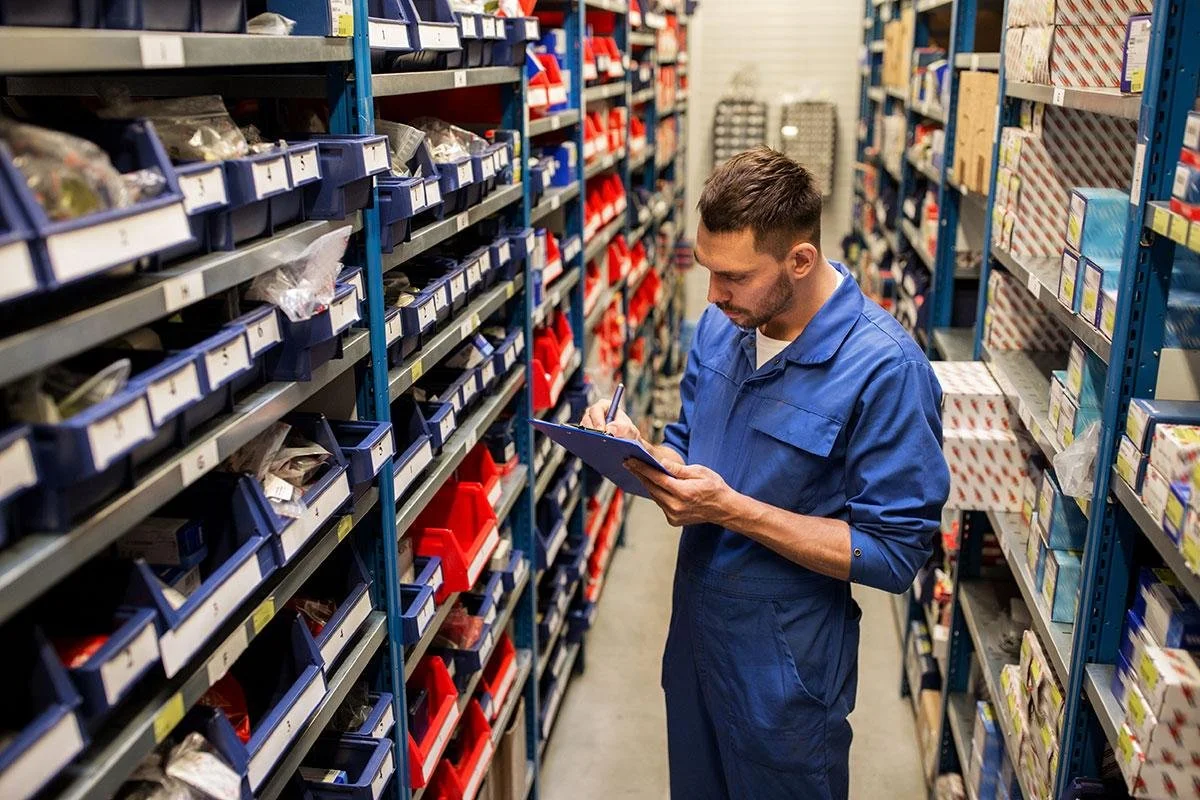 Inventory professional reviewing organized MRO parts and supplies in an industrial stockroom.