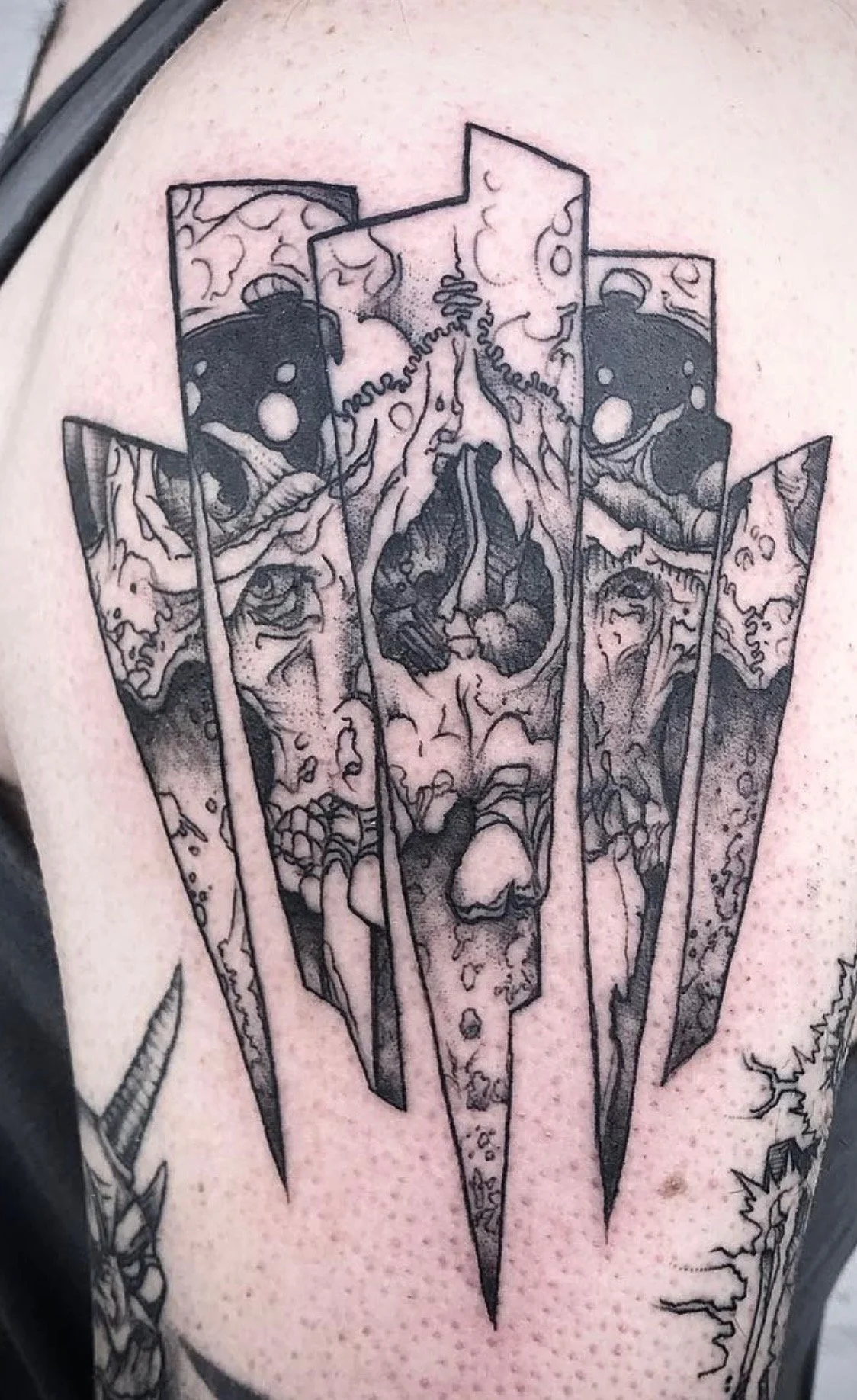 Black ink tattoo of a Clownfish inside a broken popsicle stick on skin.