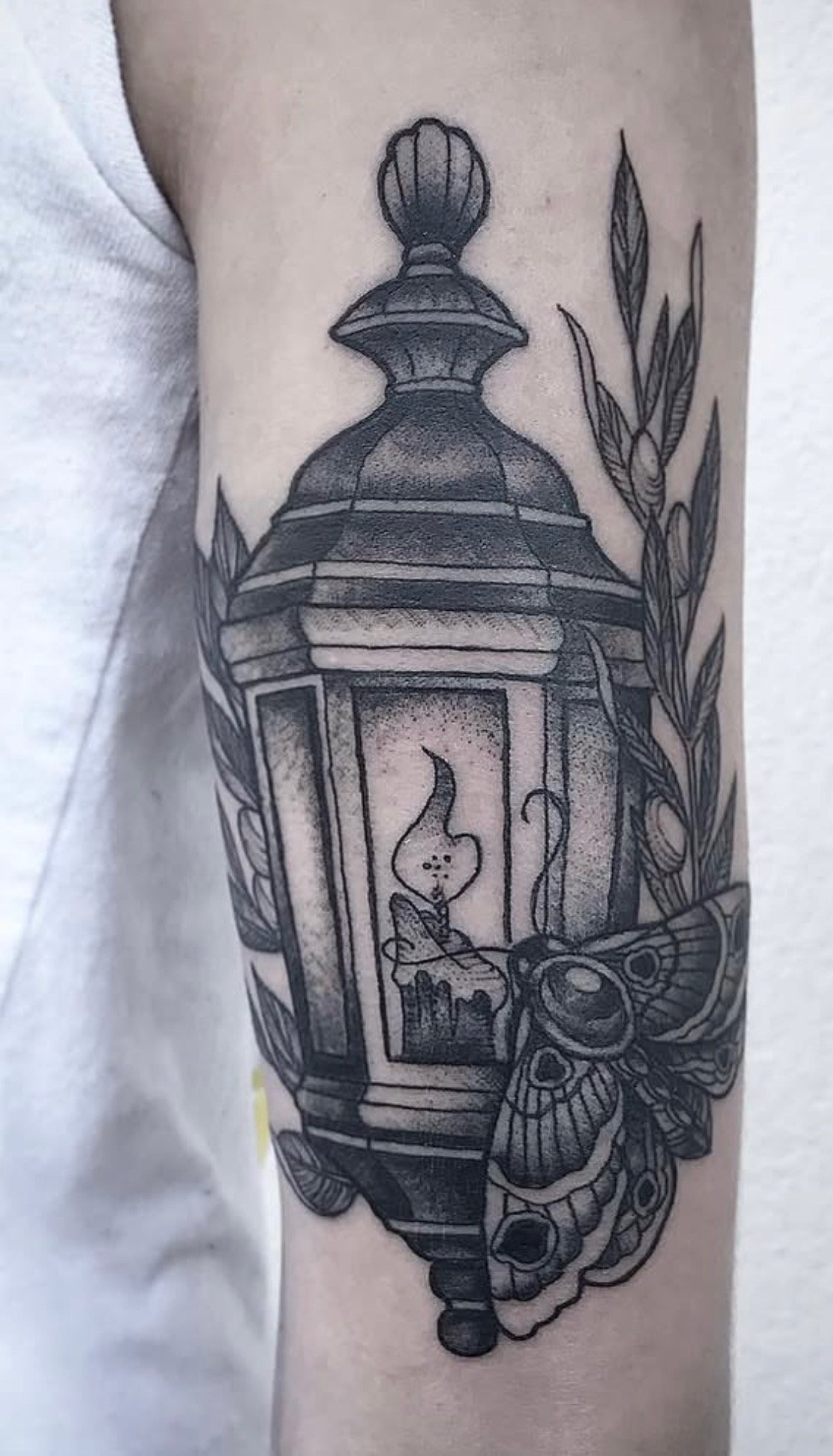 Black and grey lantern tattoo by Russell at Handsome Devil Tattoo in Saddle Brook, NJ. Featuring smooth shading, rich contrast, and timeless tattoo craftsmanship, this custom lantern design captures classic style with a bold black and grey approach.