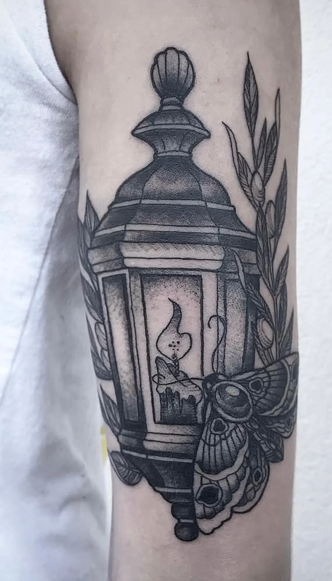 High‑contrast American Traditional lantern tattoo by Russell Kelley at Handsome Devil Tattoo Co, featuring bold linework, saturated black shading, and a glowing light source that highlights his signature realism‑infused traditional style.