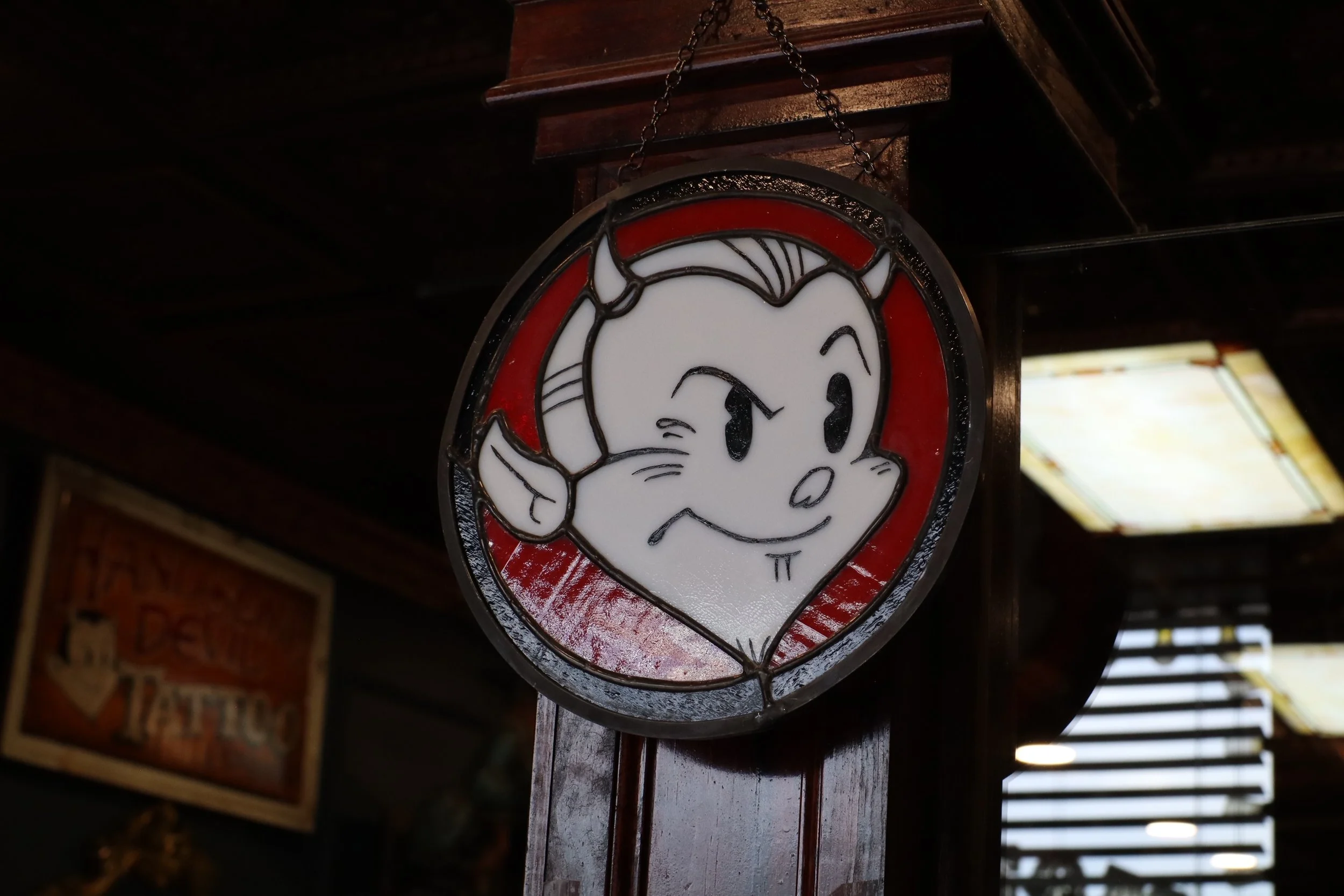 Vintage decor and Handsome Devil Tattoo Company sign displayed inside the tattoo studio in Saddle Brook, New Jersey.