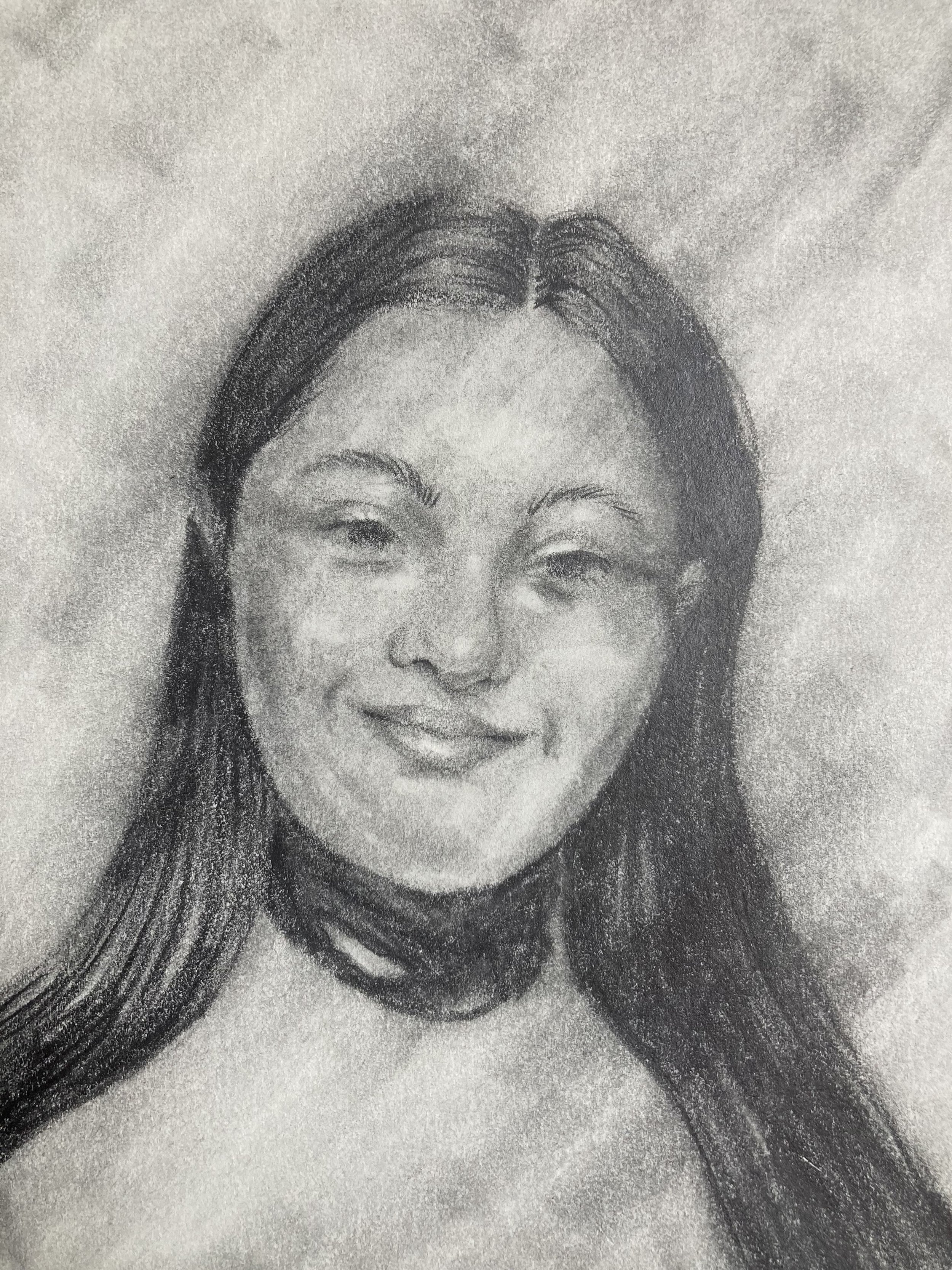 A black and white portrait of a woman with Down Syndrome with straight hair, smiling gently.