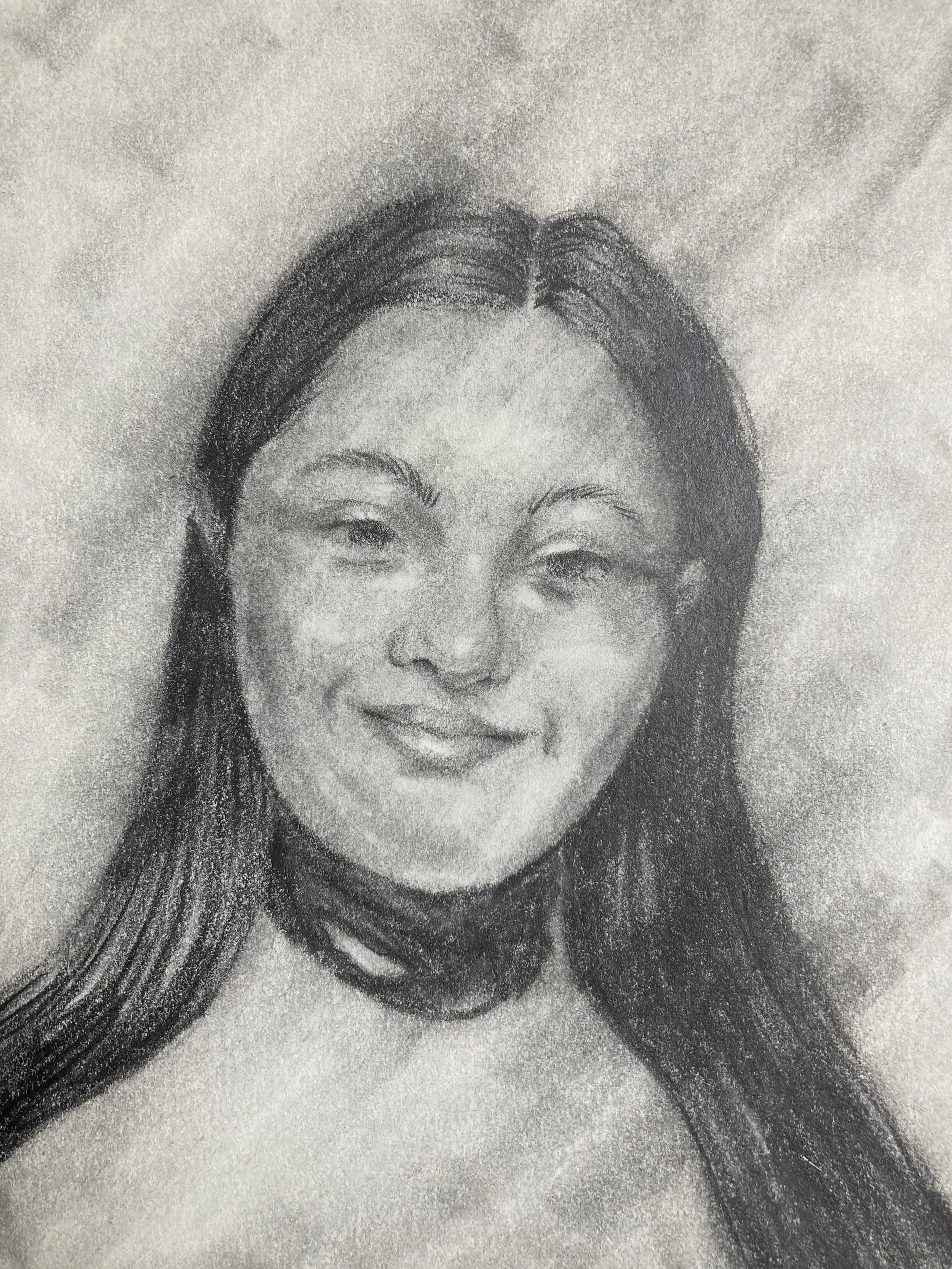 A close-up black and white sketch of a woman's face with long hair, smiling gently.
