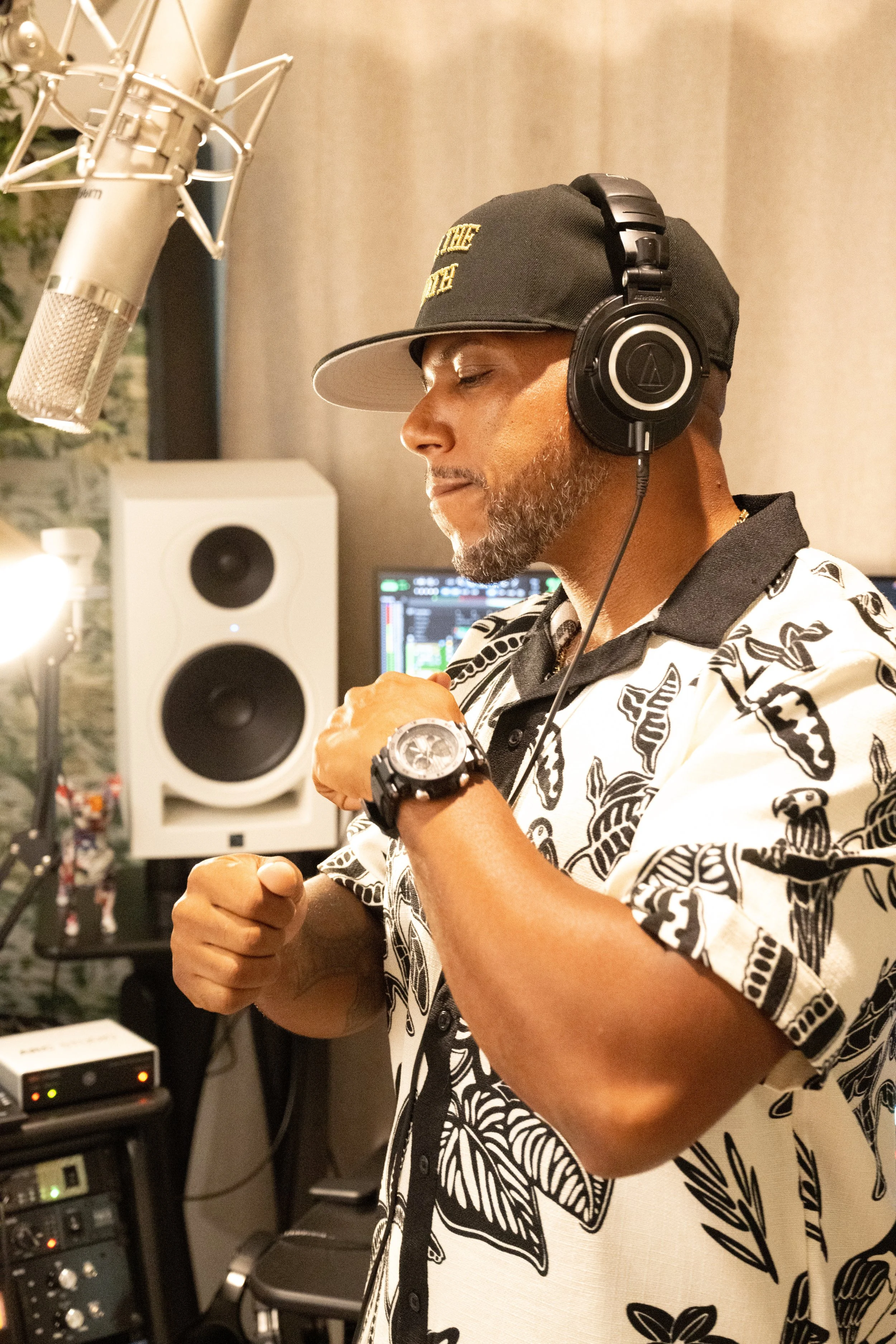 T3 The Servant in black hat and headphones adjusting music equipment in a sound studio.