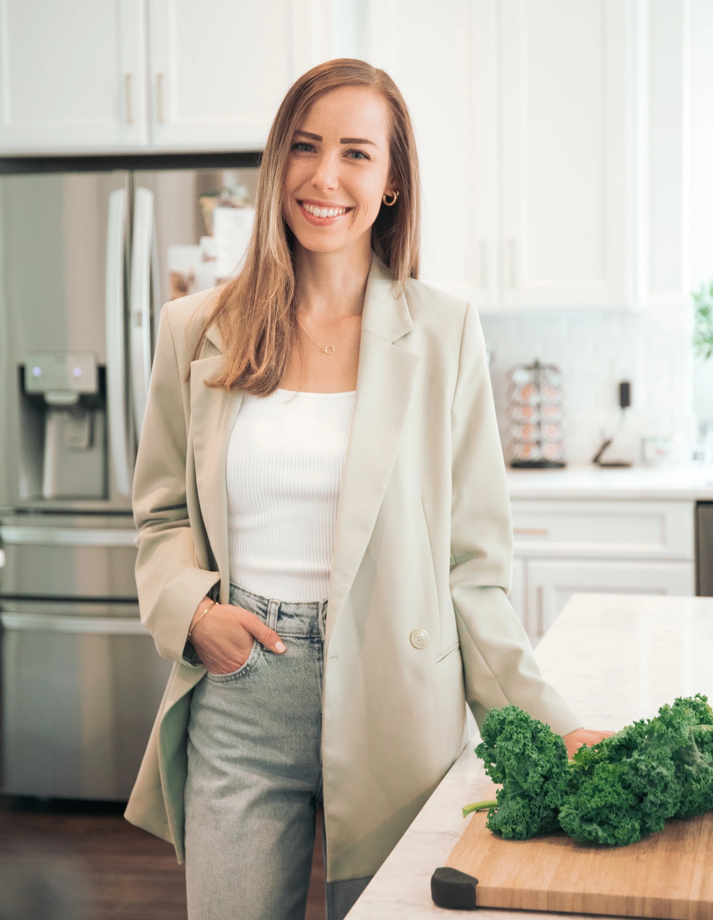 Registered Dietitian Ashley Tweddle in a kitchen with fresh vegetables.