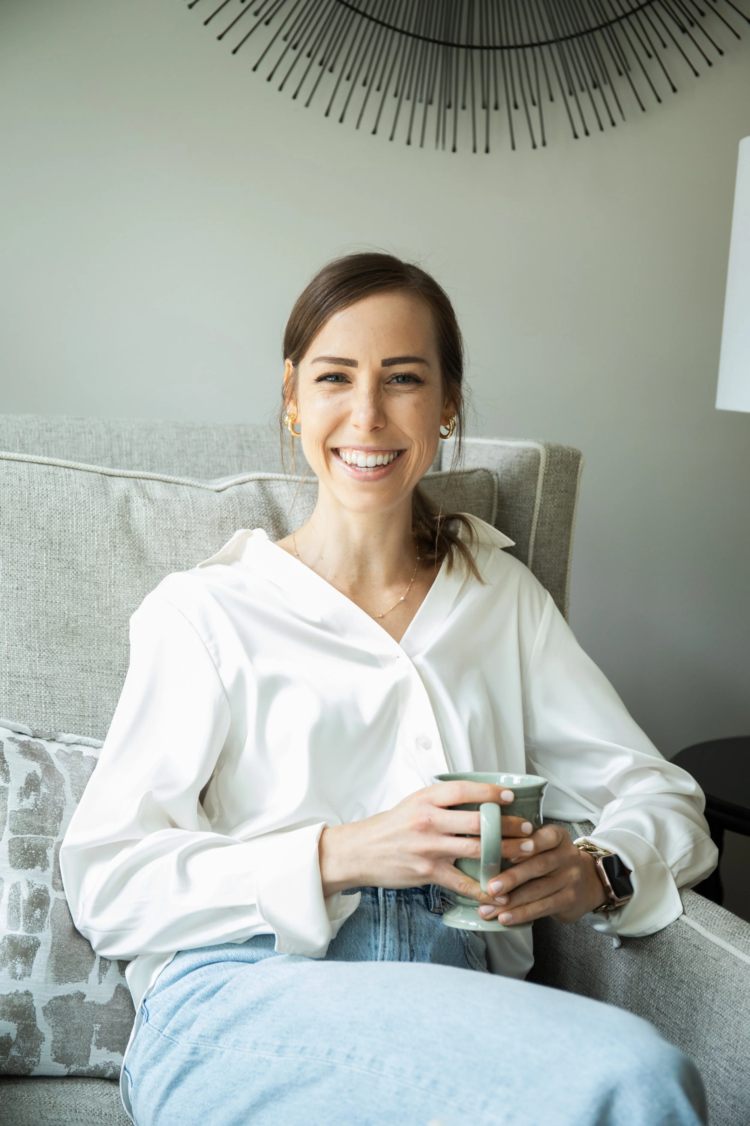 Ashley Tweddle sitting with a mug in a relaxed home setting.