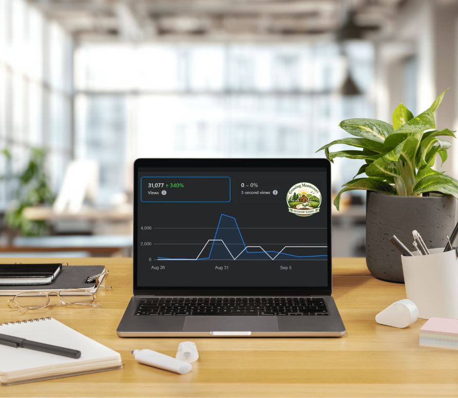 Laptop displaying a graph with a logo reading "Growing Montessori Outdoor School, Inc." on a wooden desk in a bright, modern office with plants and office supplies.