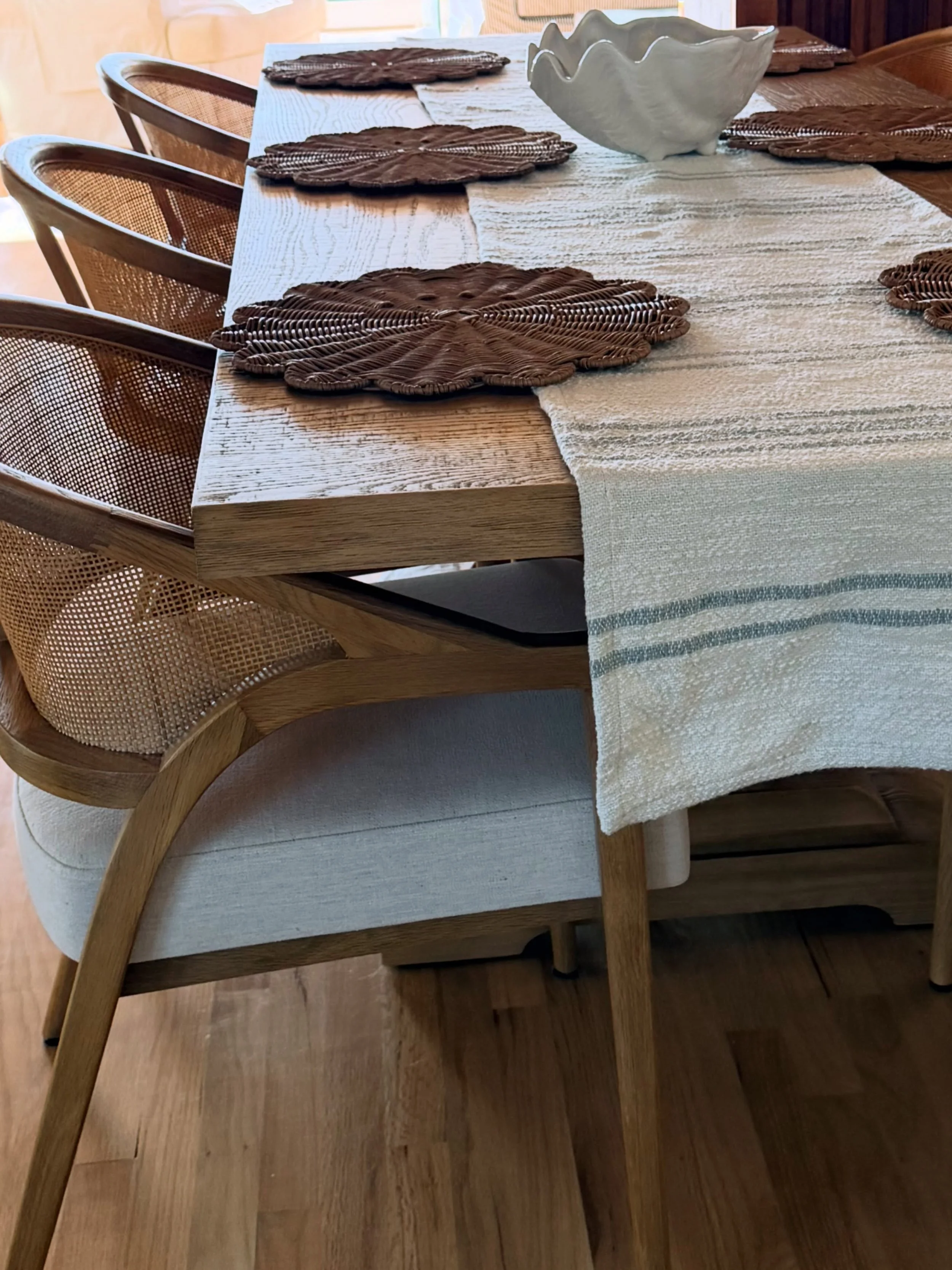 Warm wood tones, woven textures, and just a touch of blue. 🤎

We love creating spaces that feel collected, comfortable, and full of personality. This dining space is all about letting the details do the work&mdash;from the cane-back chairs and scall