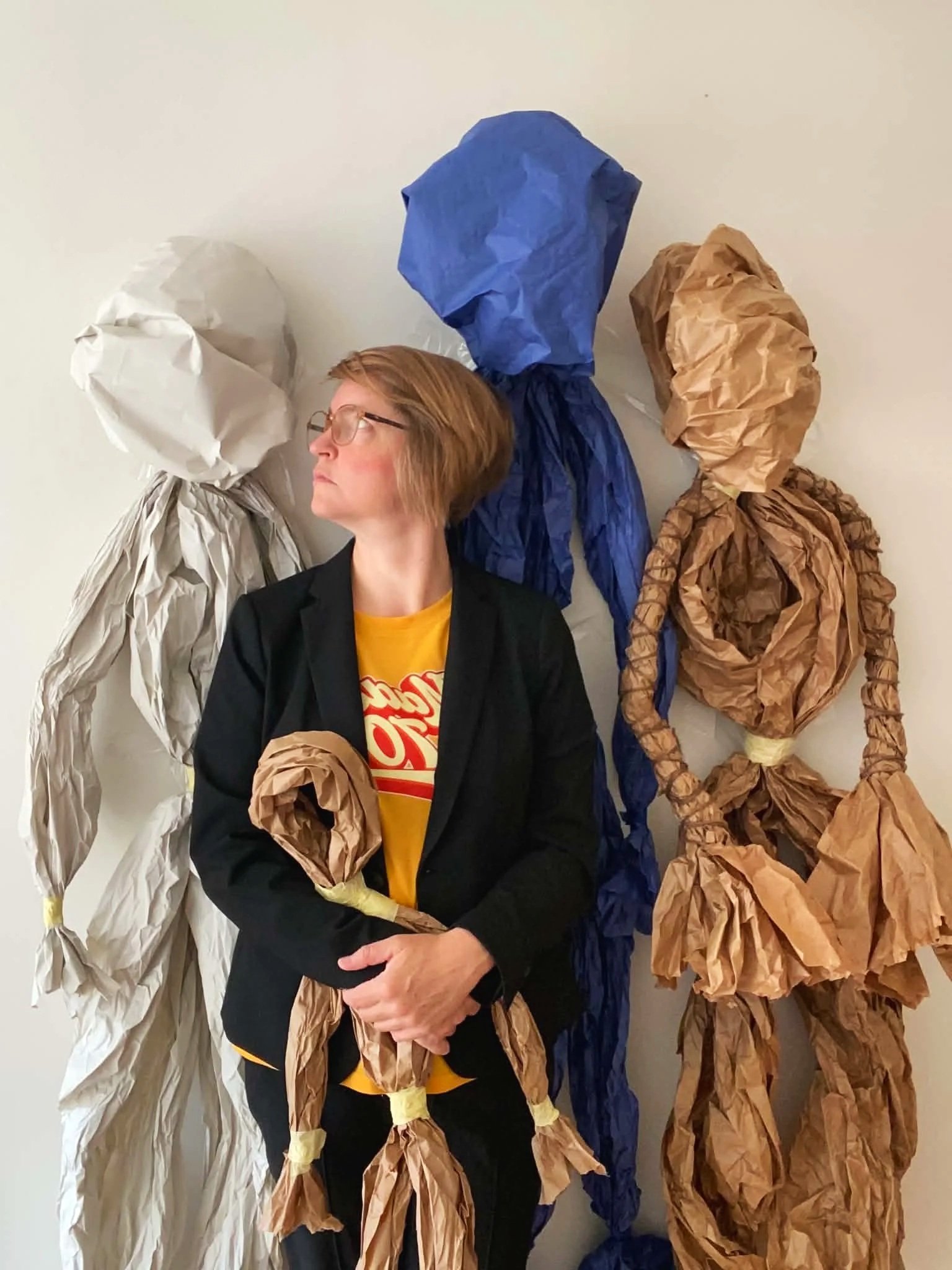 Laura Geiger standing with multiple life-size paper puppets