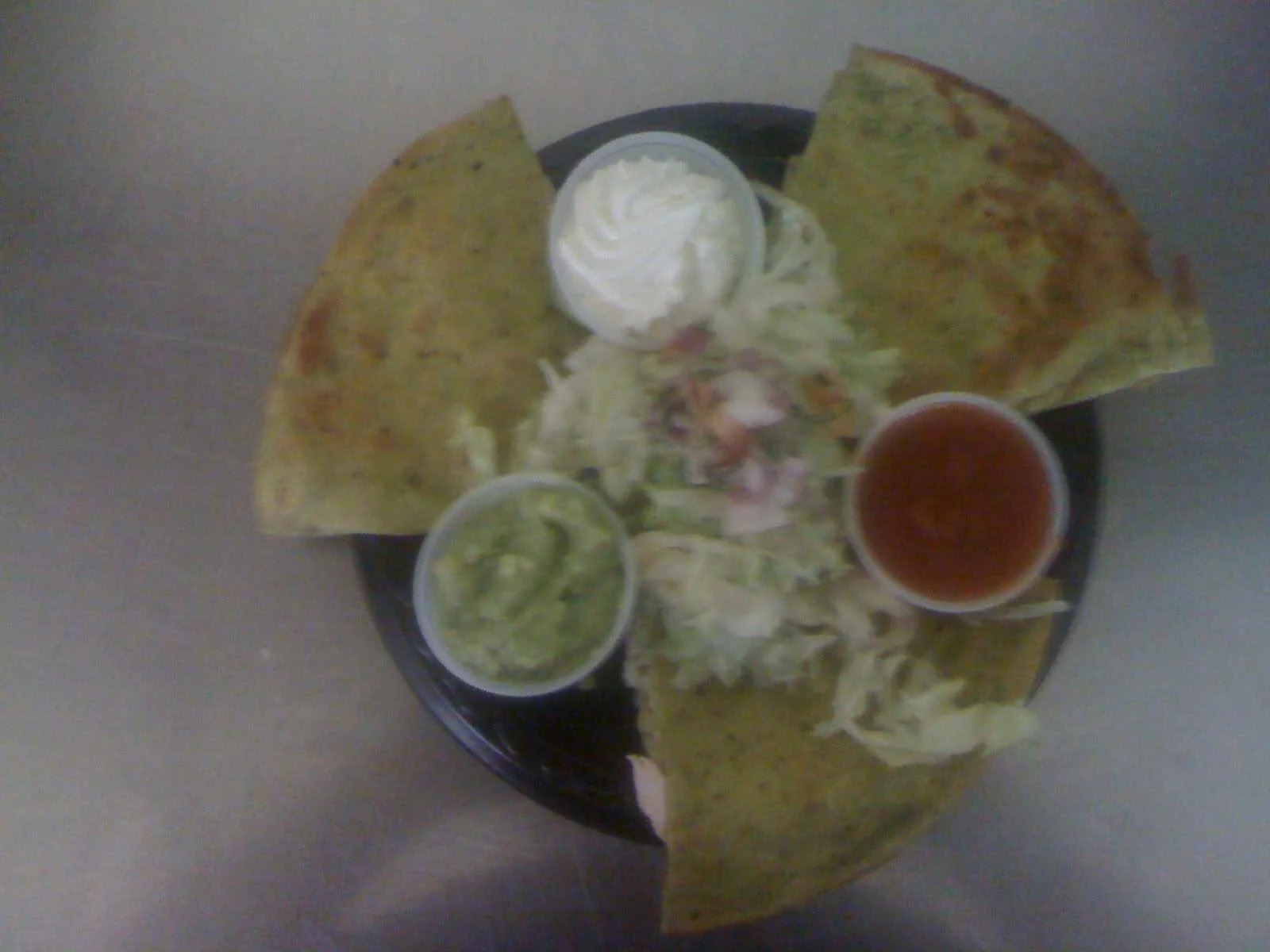 Plate of Mexican food with tacos, chips, guacamole, sour cream, and salsa.
