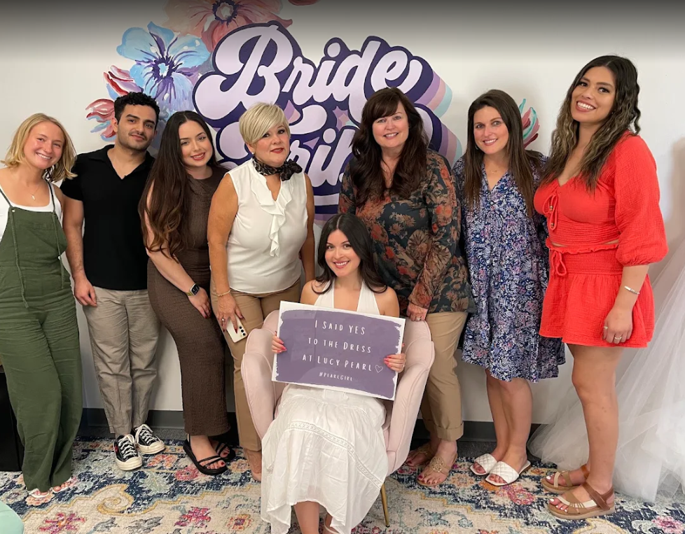 Group of women celebrating at a bridal event, with a sign that reads, 'I said yes to the dress at Lucy Pearl.'