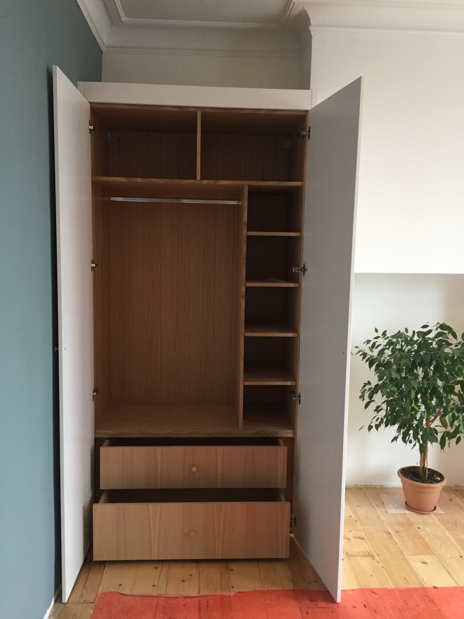 Fitted wardrobe with white shaker doors and oak veneer carcass.
