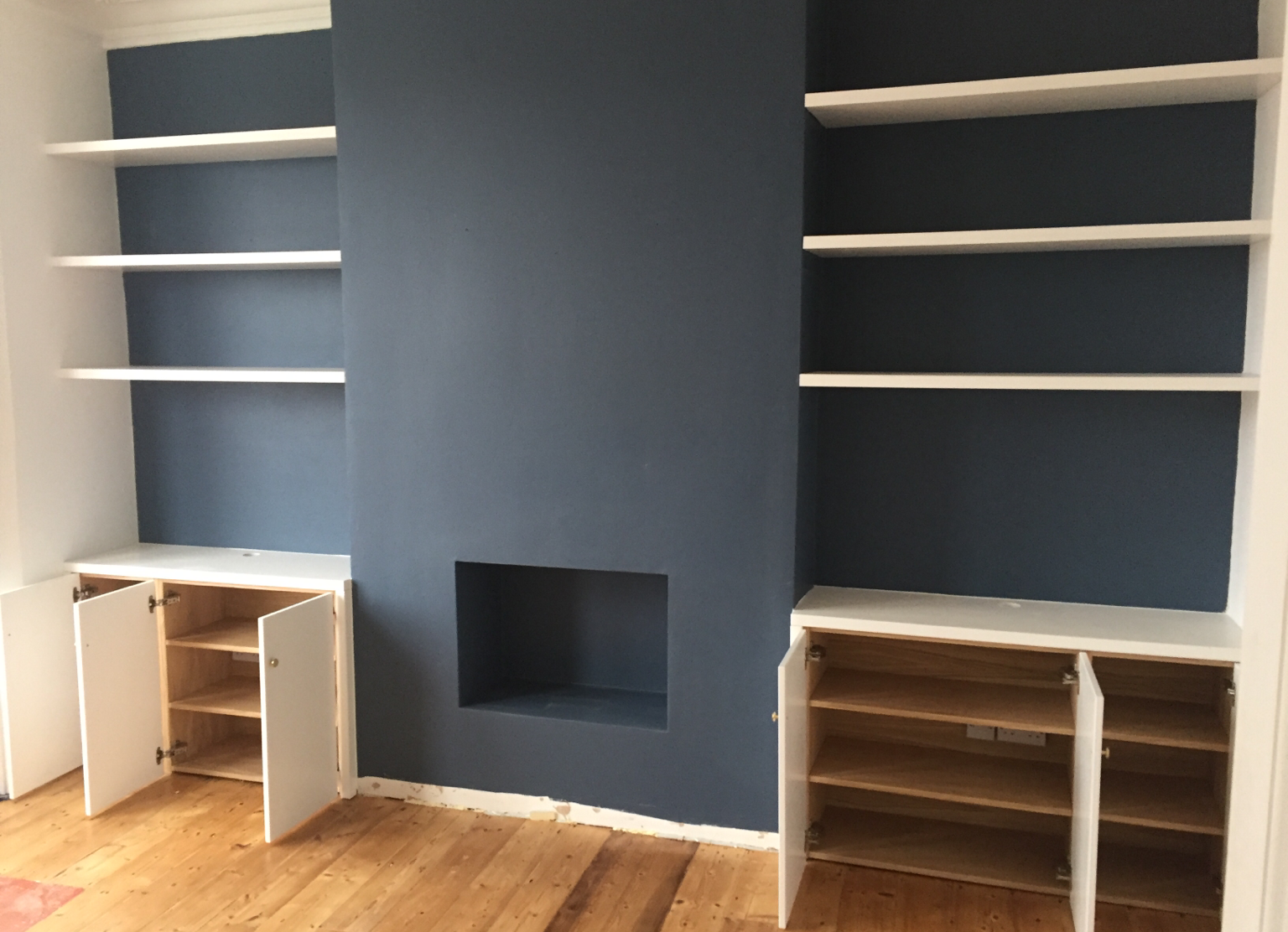 Fitted alcove units with oak veneer carcass and matching floating shelves. 
