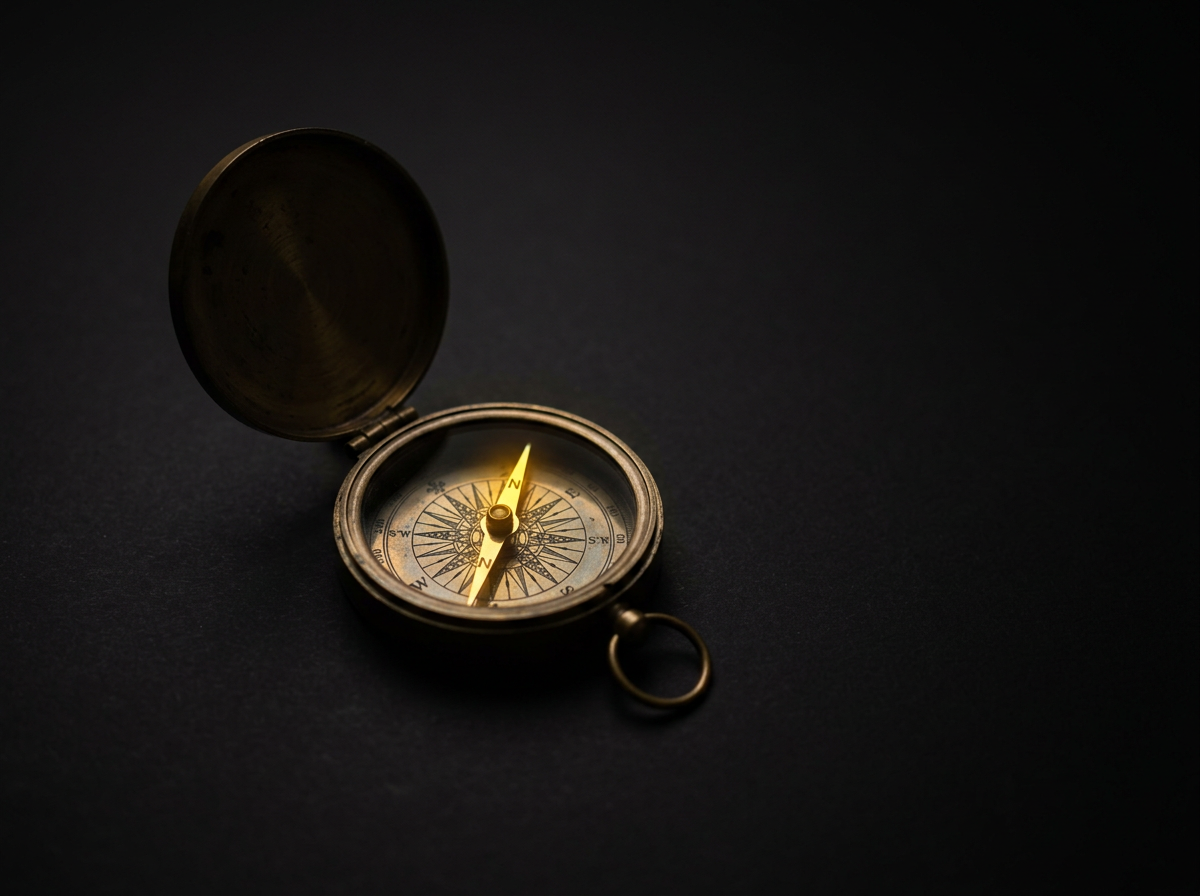 Antique compass with needle glowing gold